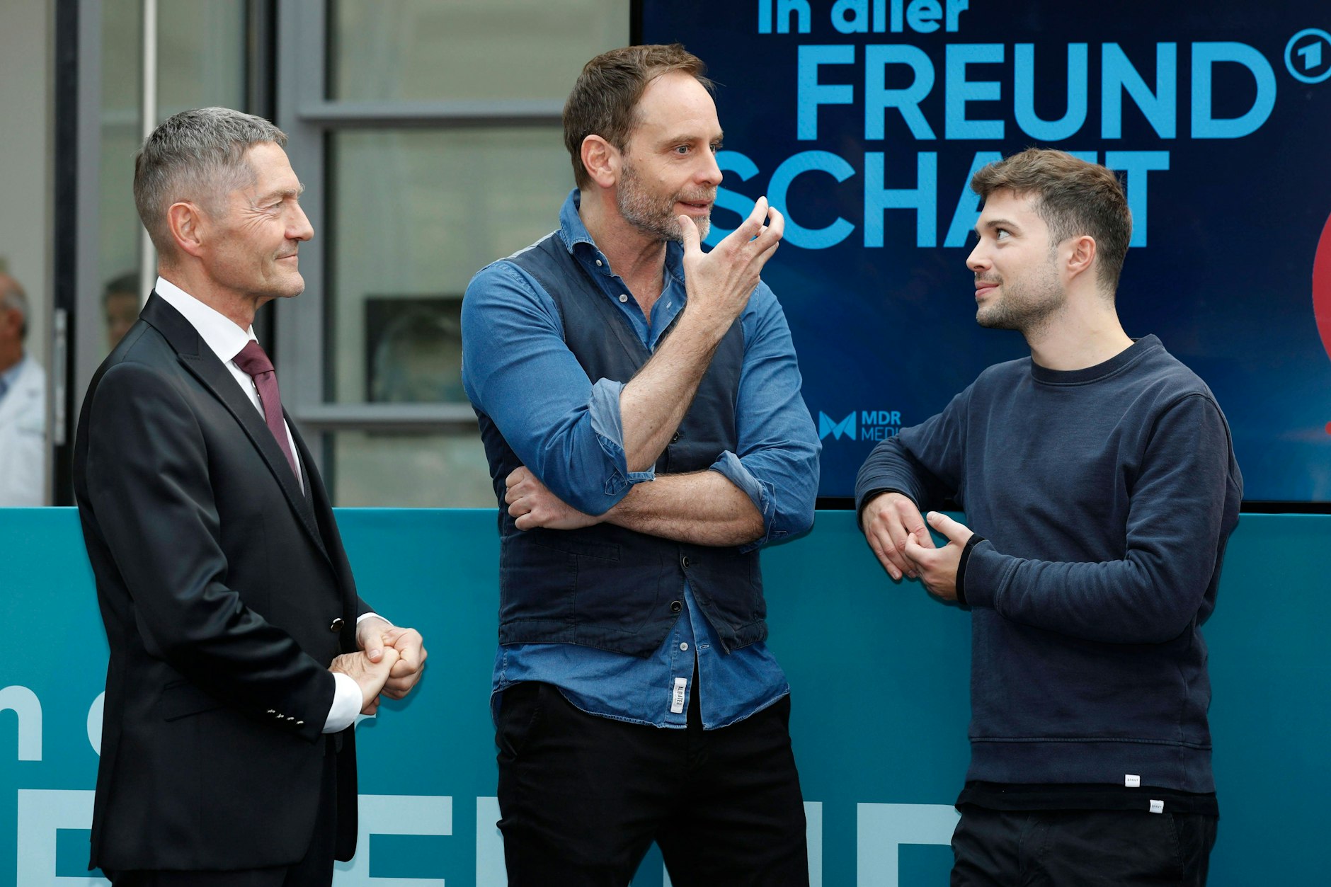 Die Schauspieler Julian Weigend (M.), Udo Schenk (l.) und Jascha Rust beim Fanfest „25 Jahre ‚In aller Freundschaft‘“ in der Media City Leipzig.