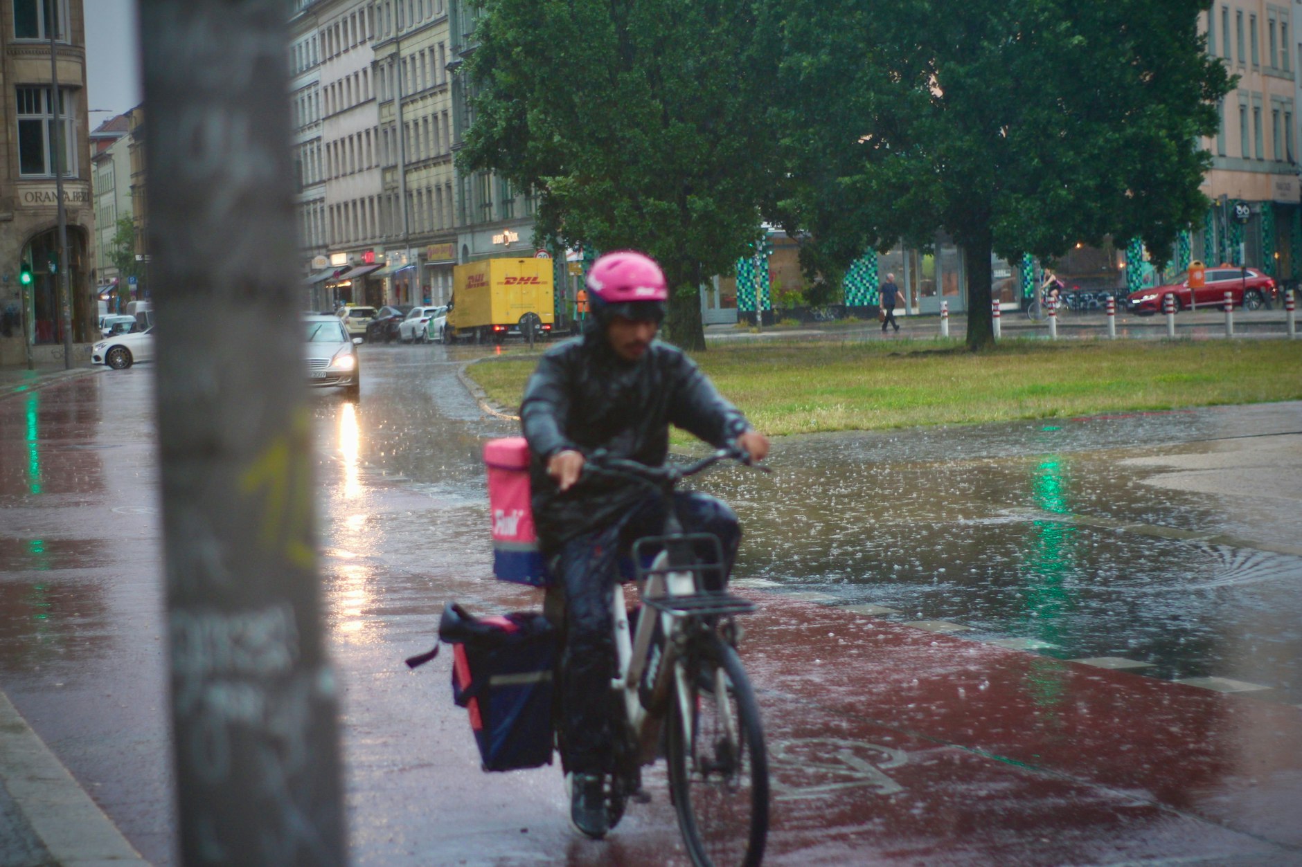 Ein flinker Lieferant von FLINK lässt sich von seiner Arbeit nicht abhalten! Er trotzt dem Wetter!