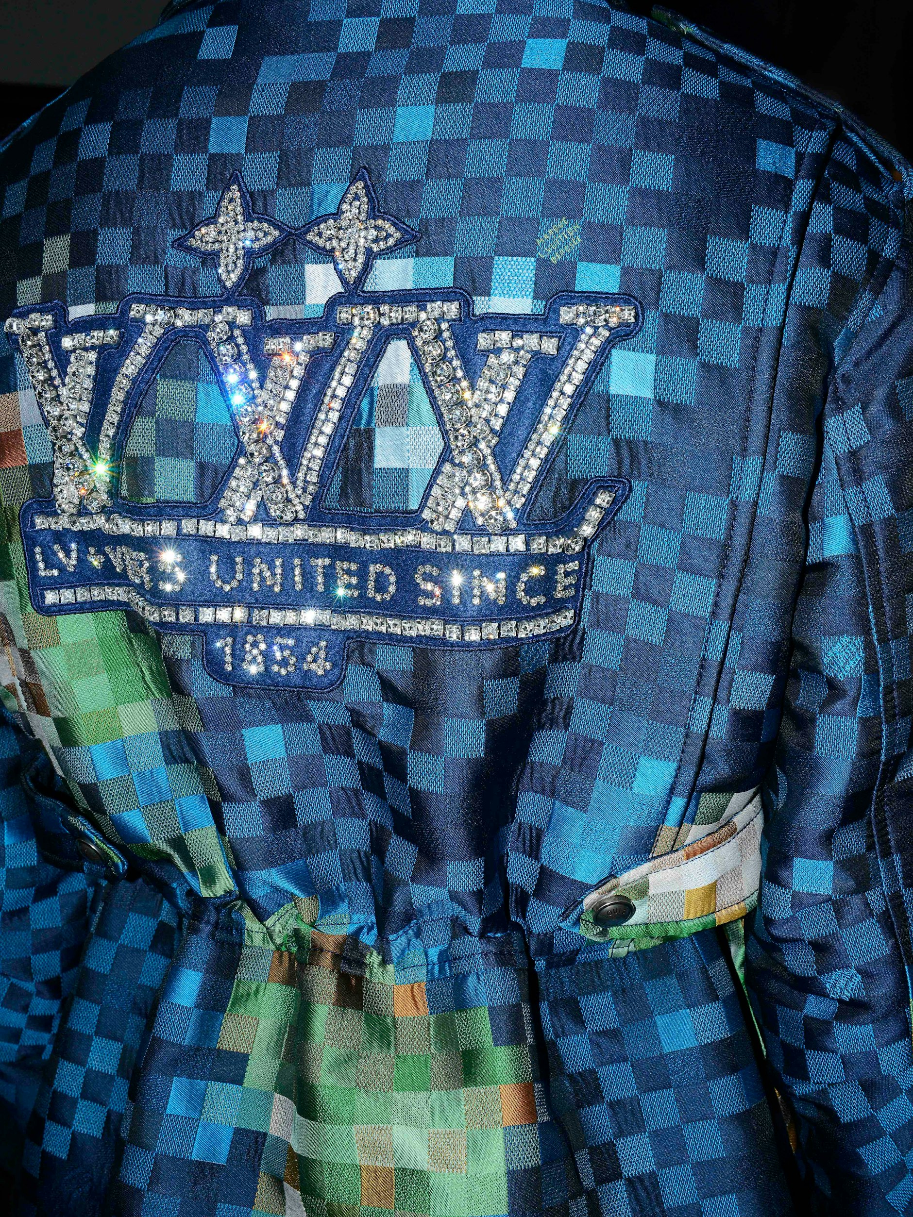 Check! 1854 ist das offizielle Gründungsjahr von Louis Vuitton. Hier in Glitzerstrass auf dem Damier-Dessin des Hauses in einem Entwurf von Pharrell Williams, präsentiert auf der Paris Fashion Week im Juni 2024.