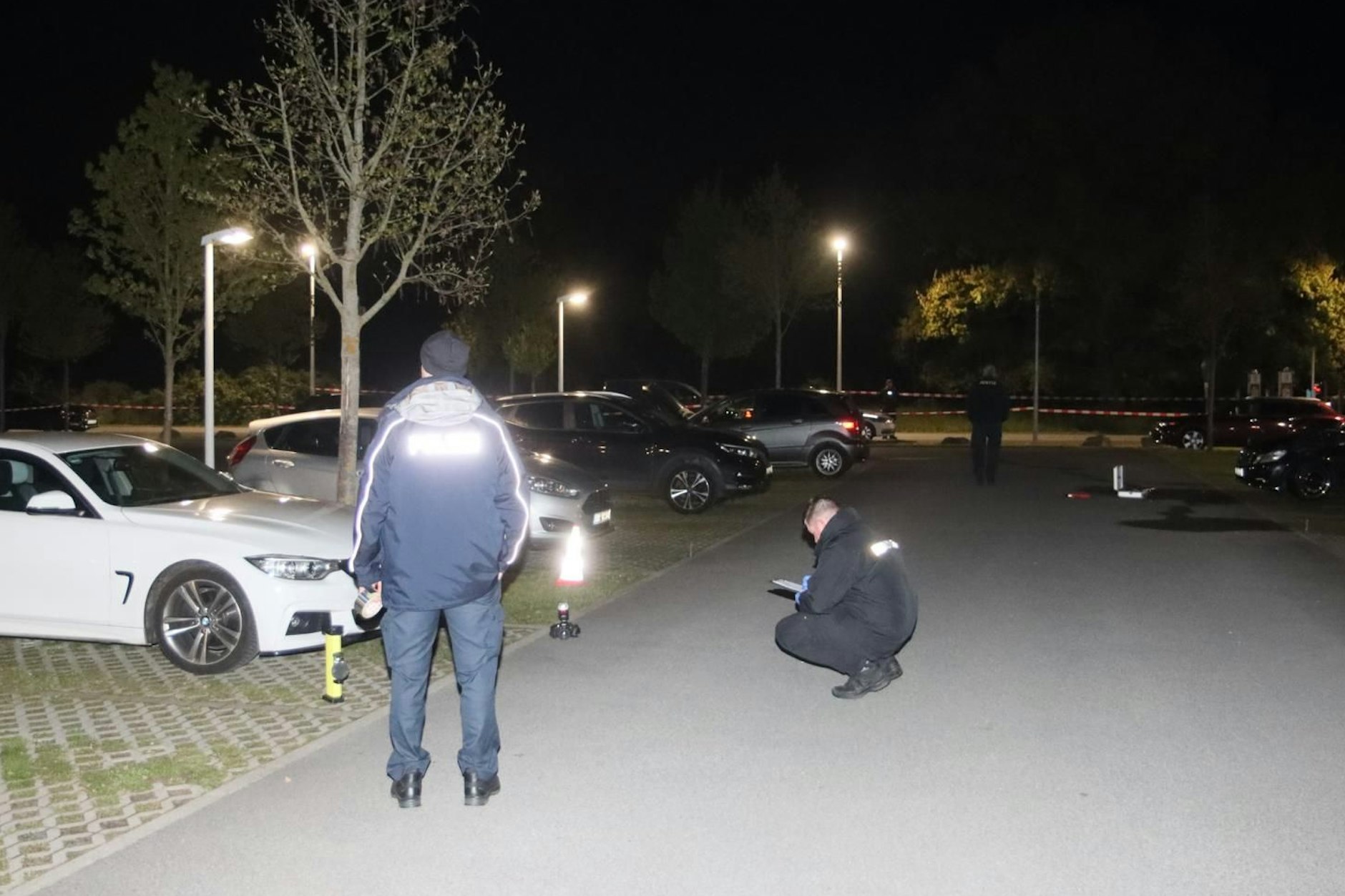 Polizisten untersuchen die Fahrzeuge, die auf dem Mitarbeiterparkplatz der Justizvollzugsanstalt Heidering angezündet wurden.
