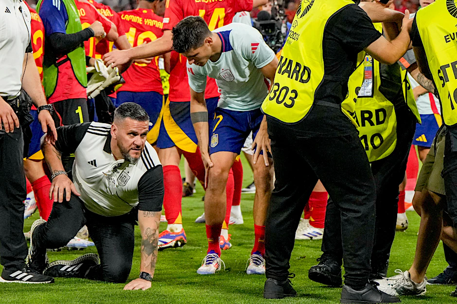 Der Ordner, der versehentlich Álvaro Morata umgegrätscht hat, steht wieder auf. Morata erkundigt sich, ob alles okay ist.