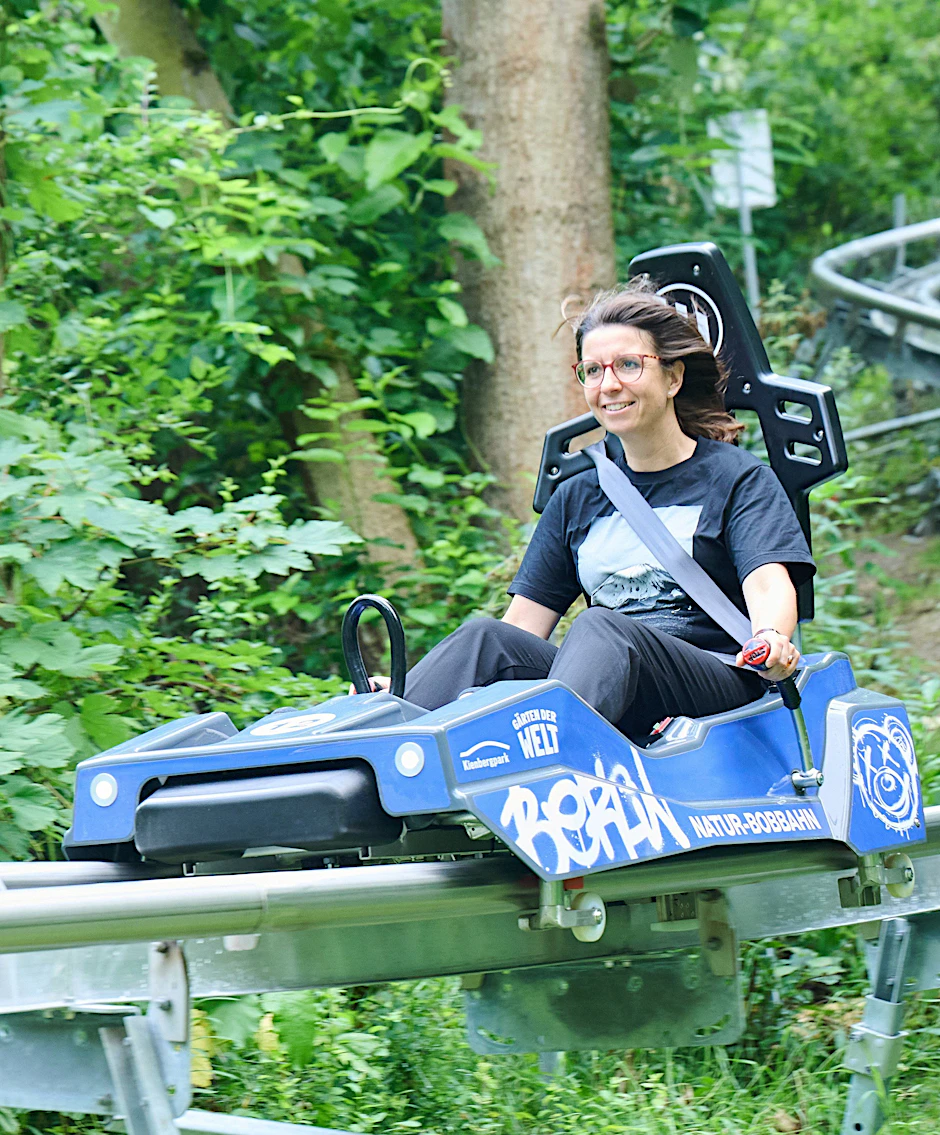 Nadja Zivkovic (CDU), Bezirksbürgermeisterin von Marzahn-Hellersdorf, fährt die Jungfernfahrt mit der Bobbahn neben den Gärten der Welt. Am Donnerstag wurde die Berliner Natur-Bobbahn im Kienbergpark wieder geöffnet.&nbsp;