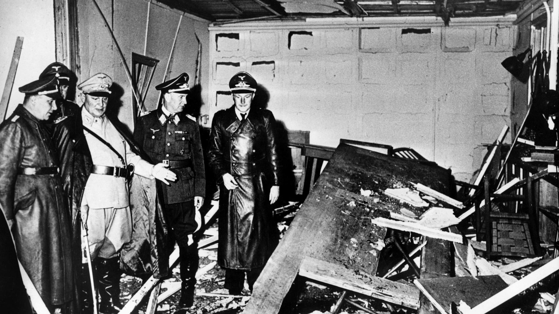 Reichsmarschall Hermann Göring (helle Uniform) und der Chef der Kanzlei des Führers, Martin Bormann (l.), begutachten die Zerstörung im Raum der Karten-Baracke im Führerhauptquartier Rastenburg, wo Oberst Stauffenberg am 20. Juli 1944 eine Sprengladung zündete. 