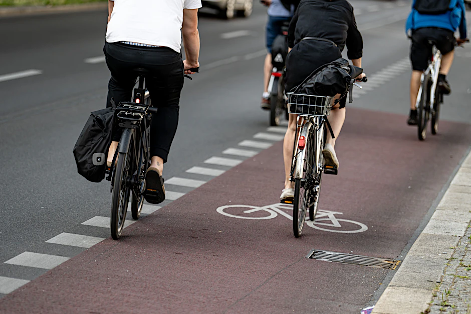 Fahrradfahrer fahren auf einem Radweg in Berlin-Friedrichshain. Die Zustimmung zum Ausbau von Radwegen ist leicht gesunken.