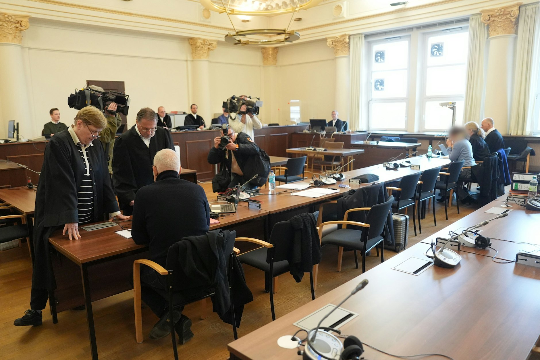 Die Angeklagte (3.v.r) und der Angeklagte (3.v.l) im Sitzungssaal im Strafjustizgebäude zu Beginn des Prozesses in Hamburg.