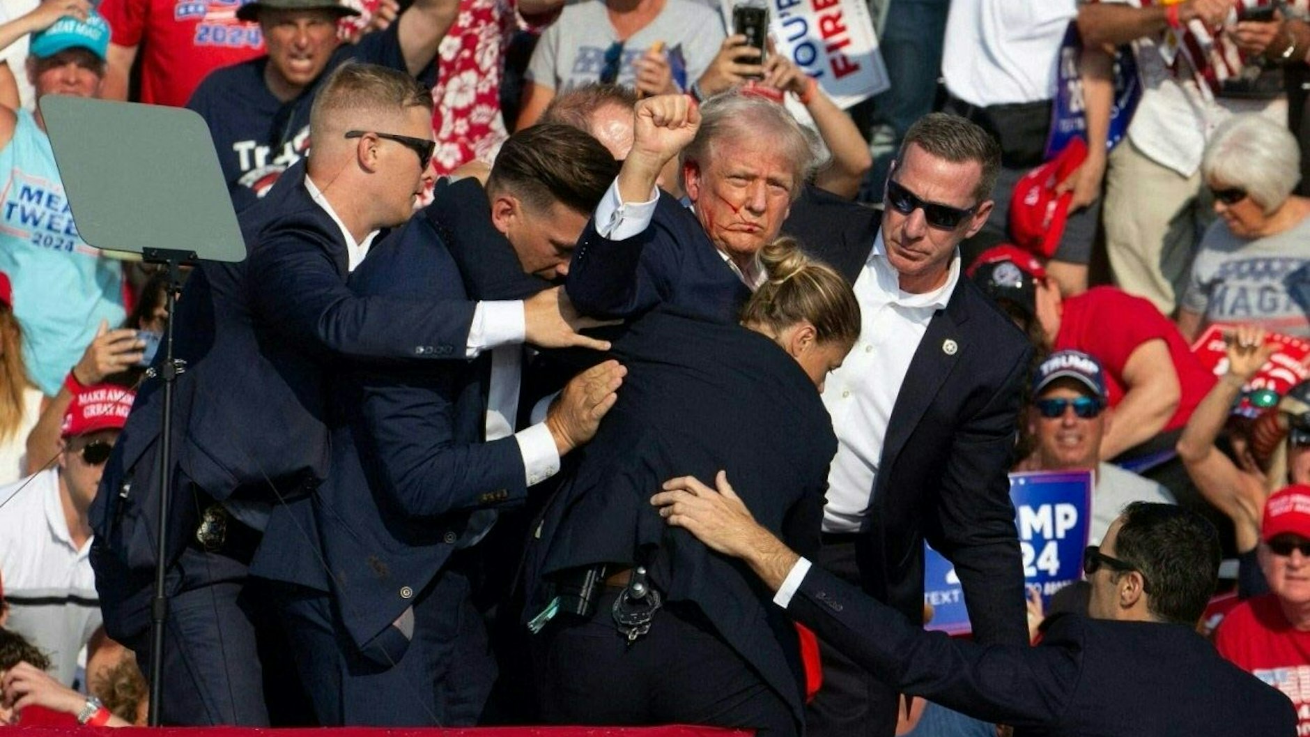 Der frühere US-Präsident Donald Trump ist bei einer Wahlkampfveranstaltung attackiert worden. Sicherheitsleute bringen ihn weg. Mit blutverschmiertem Gesicht reckt der designierte republikanische&nbsp; Präsidentschaftsbewerber die Faust in die Höhe.&nbsp;
