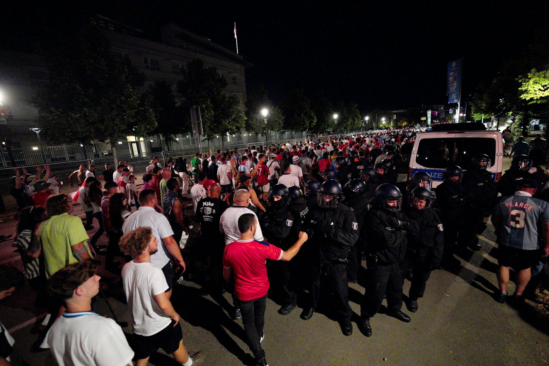 England-Fans gehen an Polizisten vorbei, als sie die Fanzone am Brandenburger Tor verlassen,