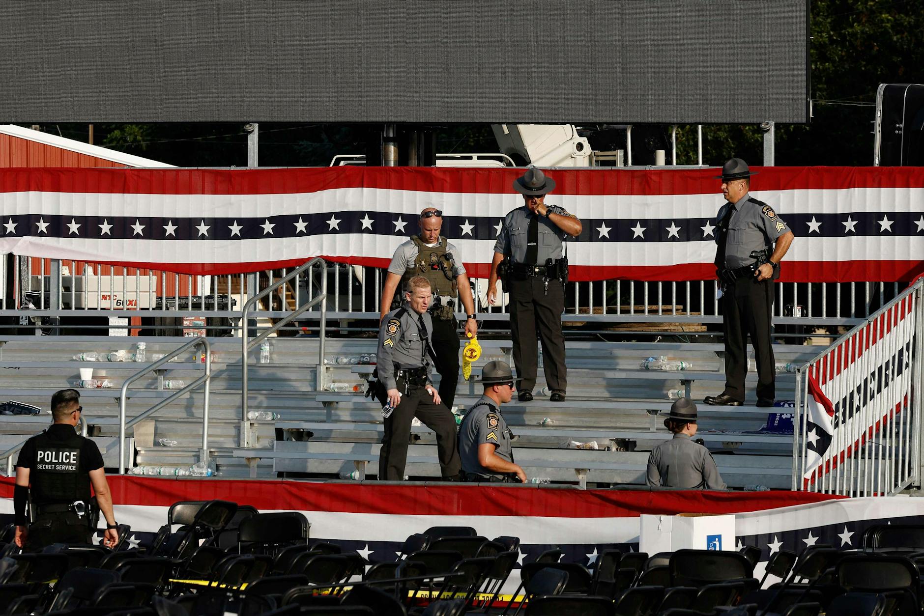 Strafverfolgungsbeamte stehen nach dem Angriff in der Nähe der Bühne von Trumps Wahlkampfkundgebung.