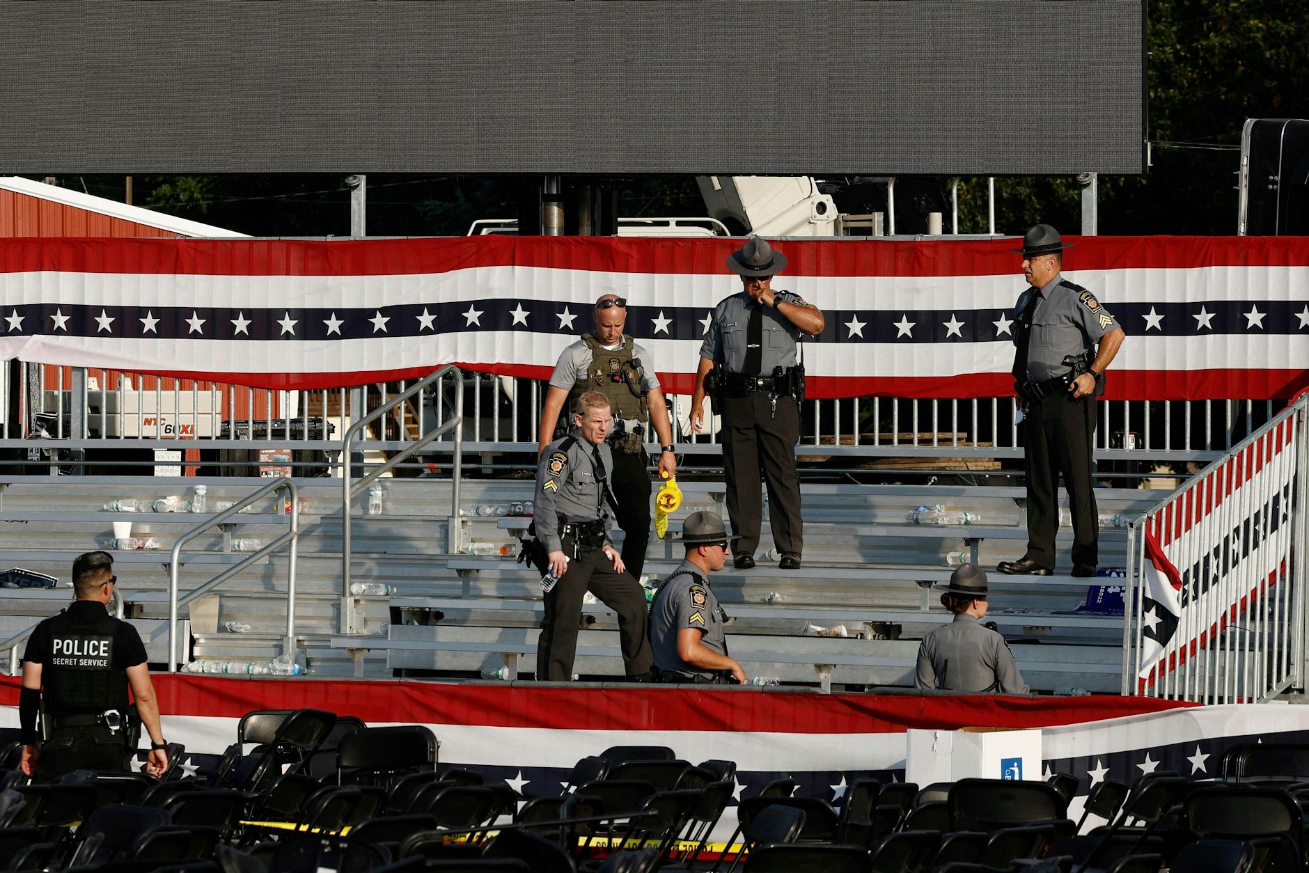 Strafverfolgungsbeamte stehen nach dem Angriff in der Nähe der Bühne von Trumps Wahlkampfkundgebung.