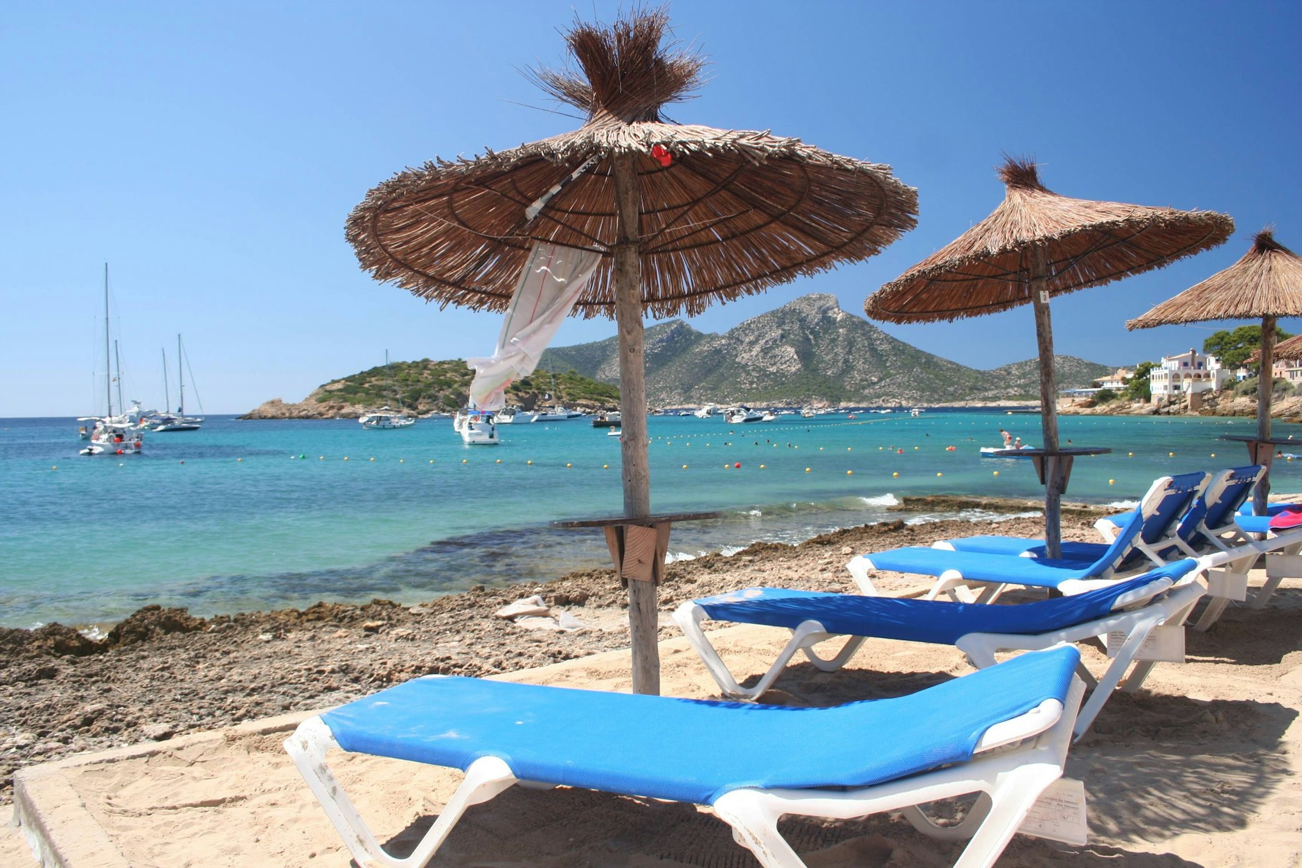 Die beliebten Stroh-Schirme am Strand von Mallorca werden immer häufiger mit Strandtüchern blockiert.