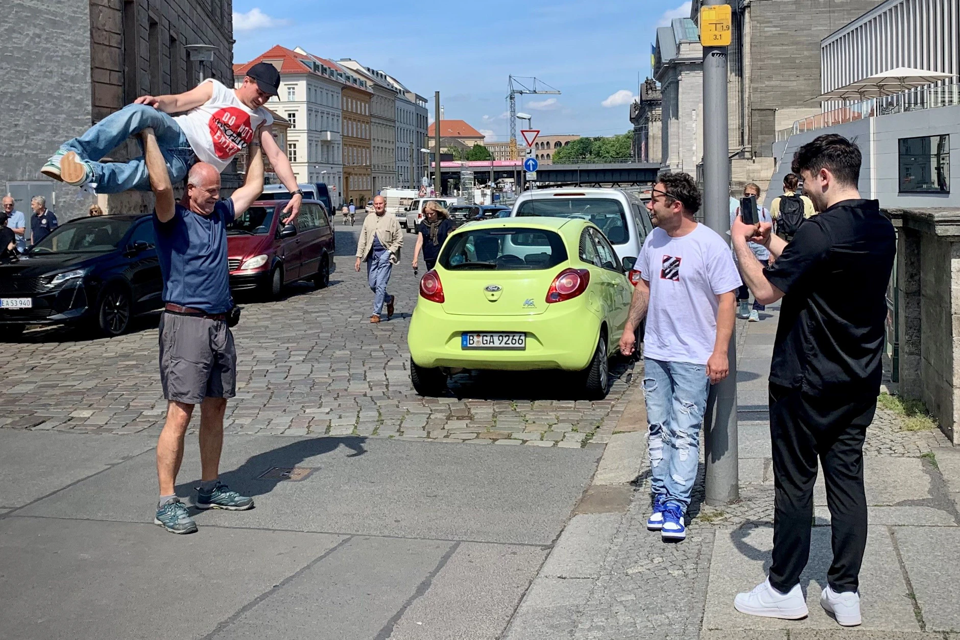 Männer beim Angeben: An der Museumsinsel stemmt ein Mann einen anderen in die Höhe.