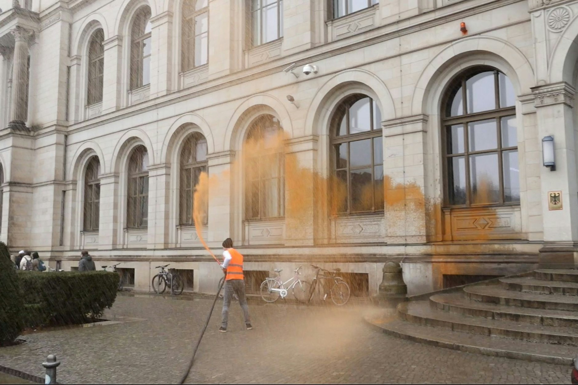 Ein Aktivist bespritzt das Bundesverkehrsministerium. Die Gruppe Letzte Generation protestierte mit der Aktion gegen die Verkehrspolitik der Bundesregierung.