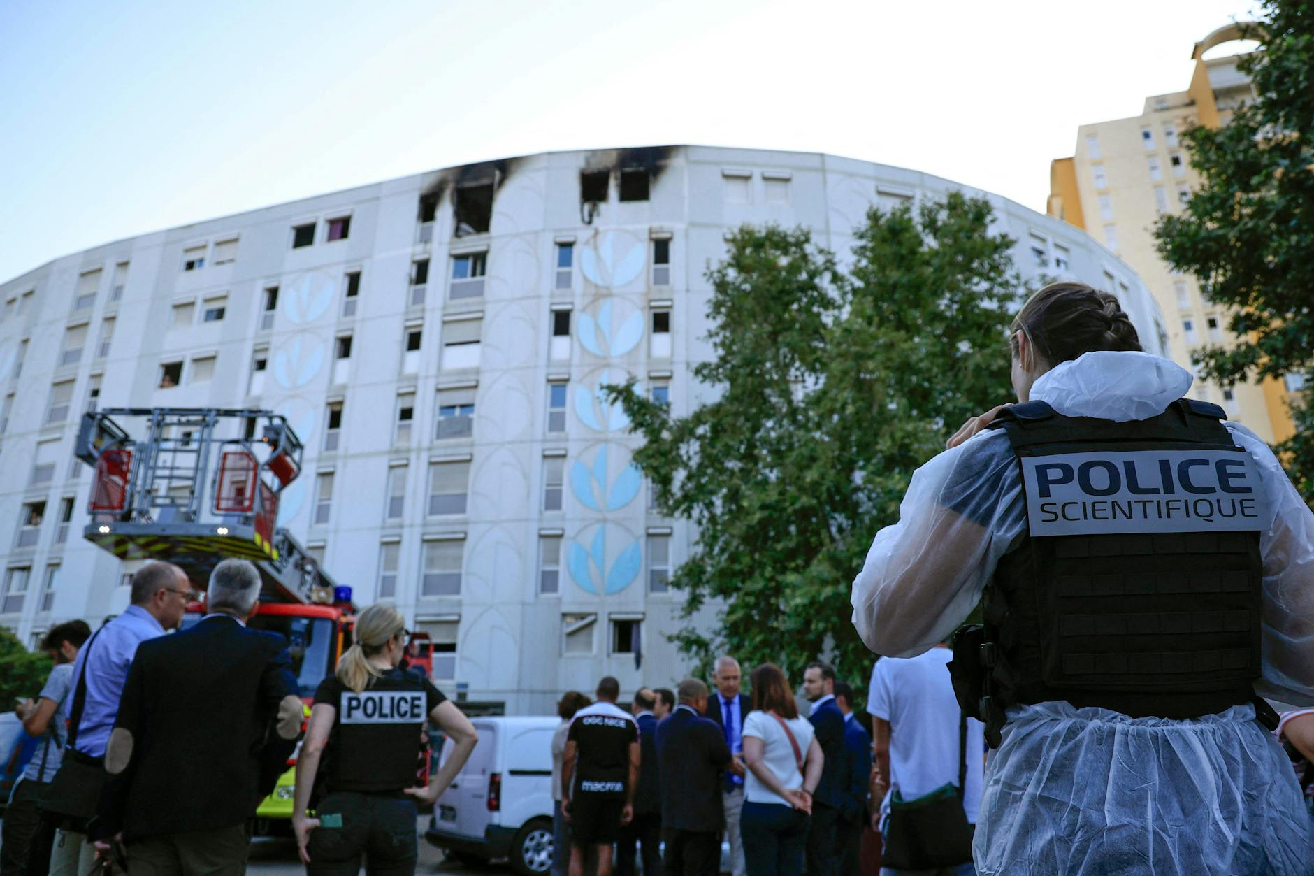 Ein Beamter der Kriminalpolizei arbeitet vor dem Gebäude, nachdem das Feuer gelöscht wurde.