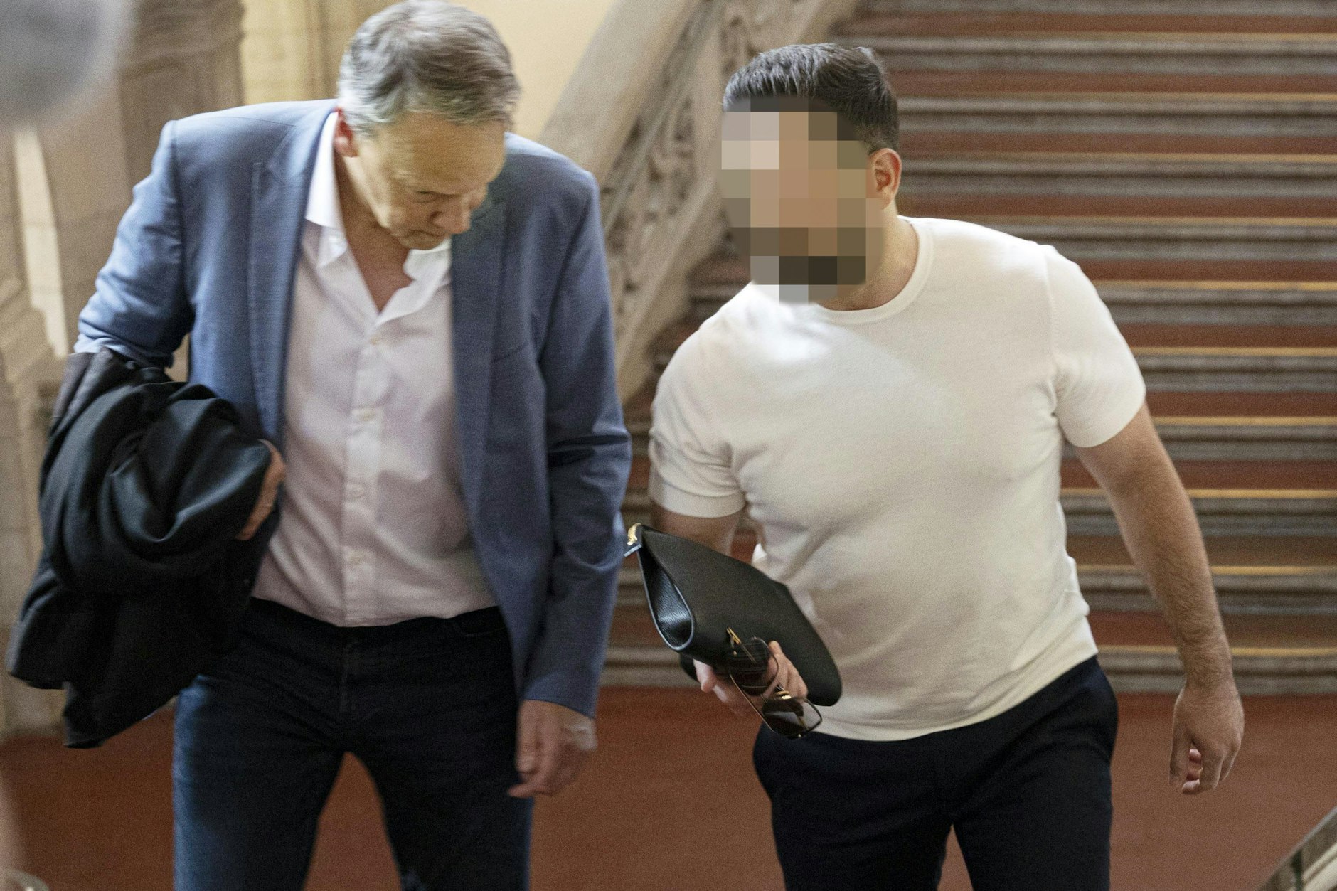 Einer der Angeklagten (rechts) auf dem Weg ins Berliner Gericht.