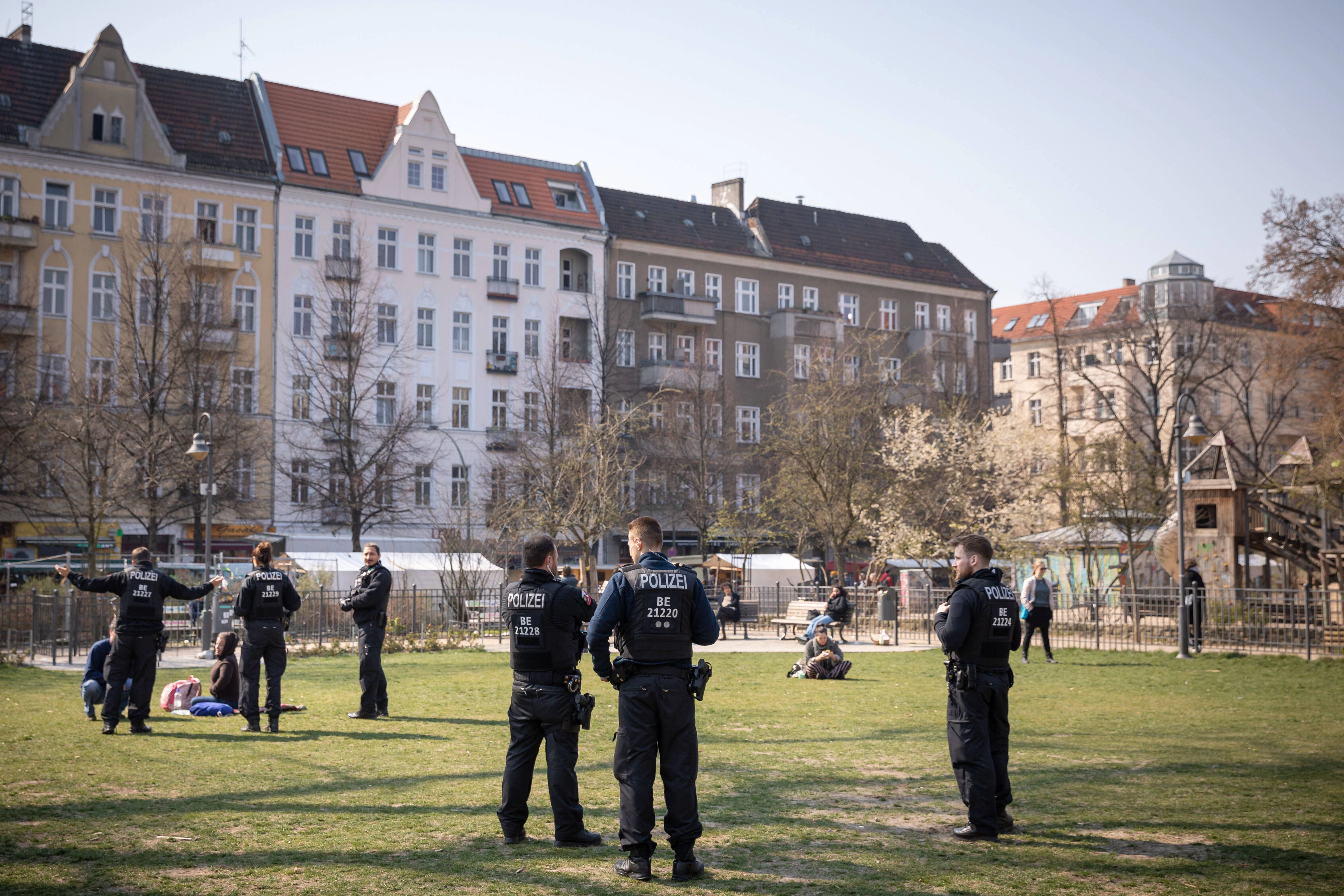 Maßnahmen zur Eindämmung der Coronavirus-Epidemie in Berlin. Polizisten weisen Passanten am Boxhagener Platz in Berlin-Friedrichshain auf die Ausgangsbeschränkungen und das Kontaktverbot hin.