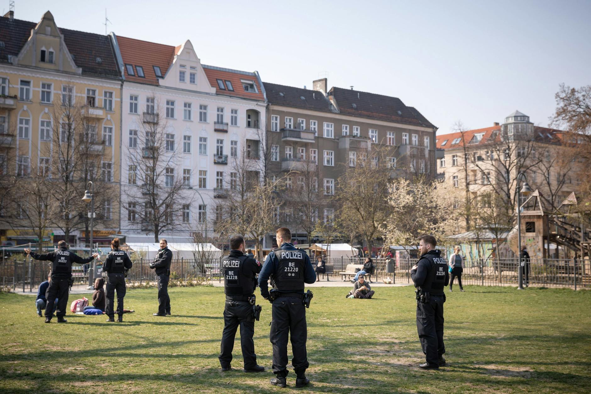 Maßnahmen zur Eindämmung der Coronavirus-Epidemie in Berlin. Polizisten weisen Passanten am Boxhagener Platz in Berlin-Friedrichshain auf die Ausgangsbeschränkungen und das Kontaktverbot hin.