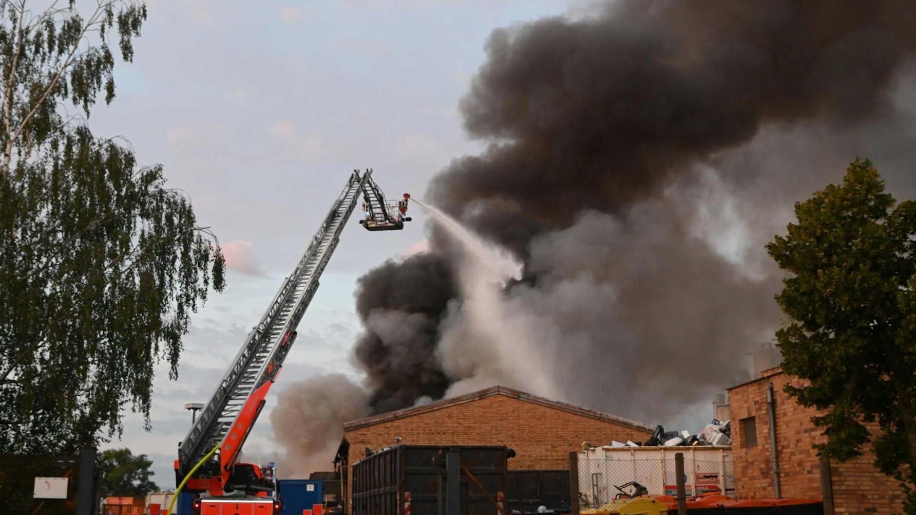 Die riesige Rauchwolke vom Brand in Hohenschönhausen war weithin zu sehen. Die Feuerwehr war mit 60 Einsatzkräften vor Ort.