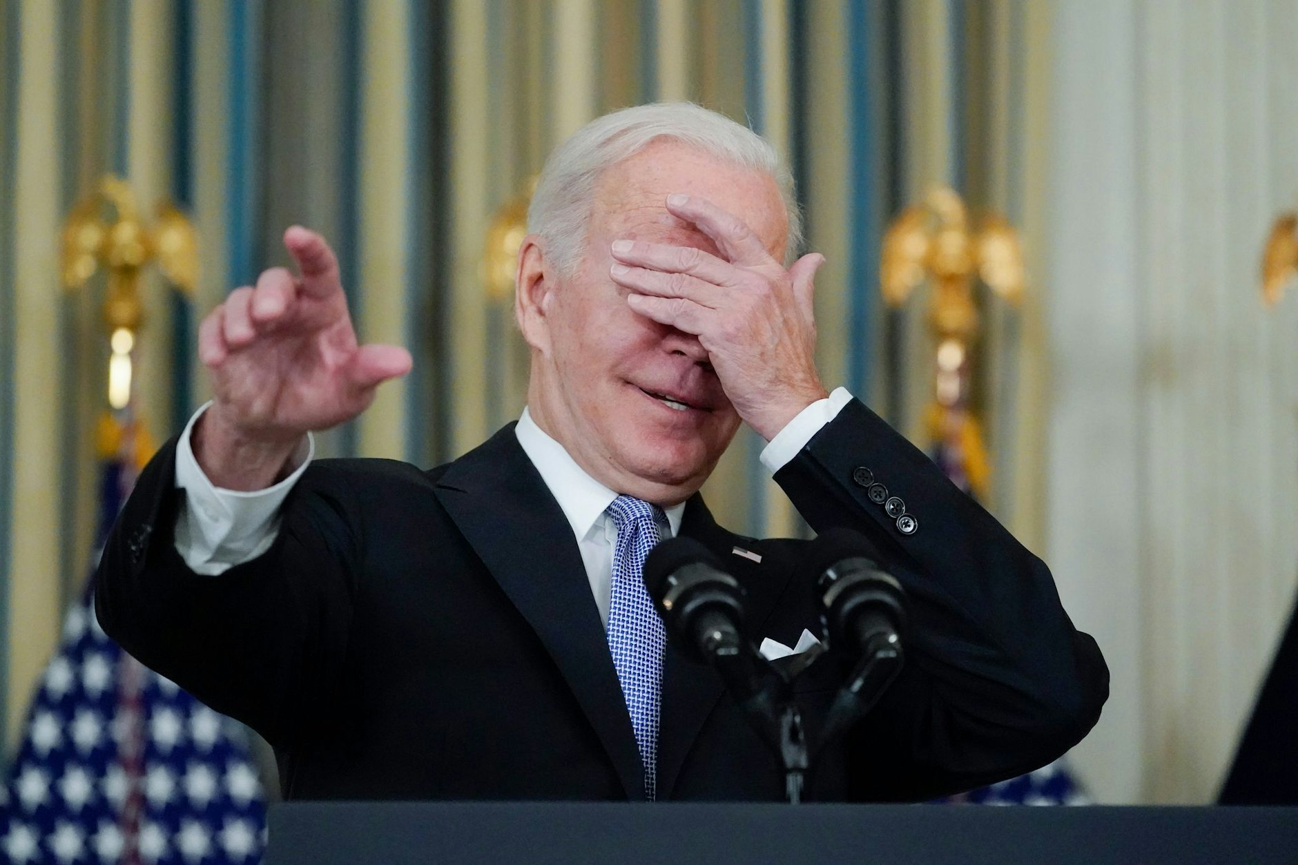 Ein jüngeres Foto: Joe Biden hält sich eine Hand vors Gesicht und gestikuliert bei einem Scherz darüber, welchen Reporter er für eine Frage anrufen soll.