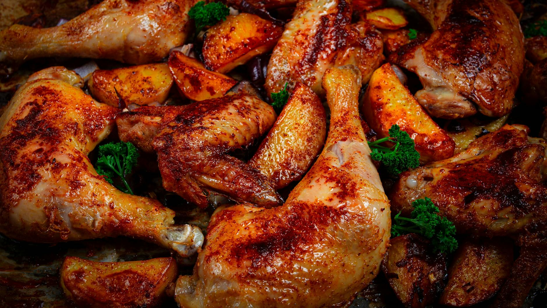 Der Clou an diesem Rezept: Im Ofen bekommen die mit Gewürzen eingeriebenen Hähnchenschenkel eine knusprige Haut. Dazu gibt es Kartoffeln und Gemüse.