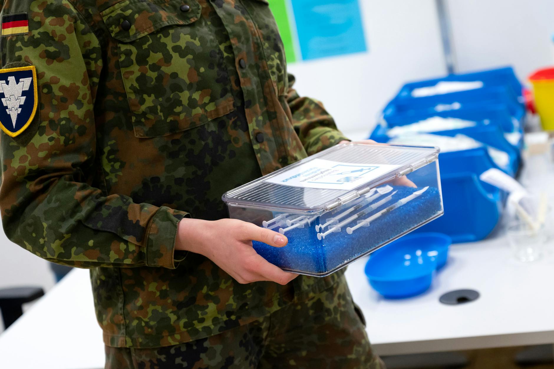 Archivbild: Eine Soldatin der Bundeswehr trägt im Impfzentrum eine Kiste mit Spritzen gegen das Coronavirus.