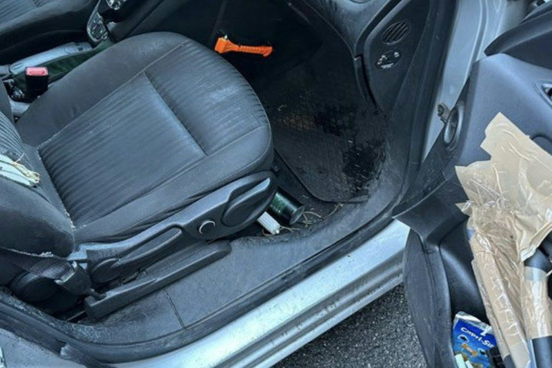 Blick in das Innere eines Polizeiwagens aus Berlin: Mit Paketband wurden Teile der Beifahrertür notdürftig befestigt.