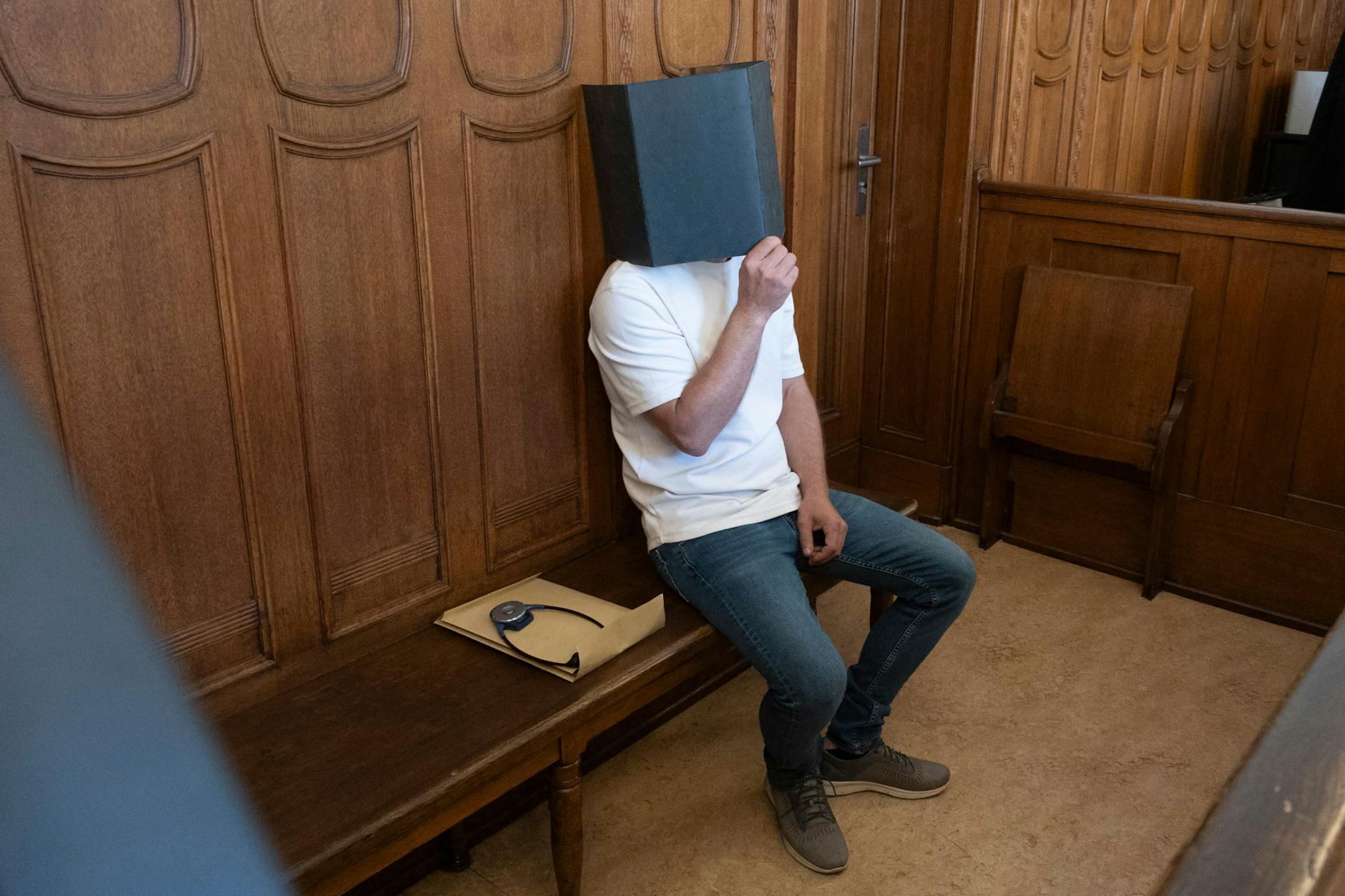 Der Angeklagte Gyunay K. verdeckt sein Gesicht auf der Anklagebank. Wegen der Vergewaltigung einer Studentin ist er zu drei Jahren Haft verurteilt worden.