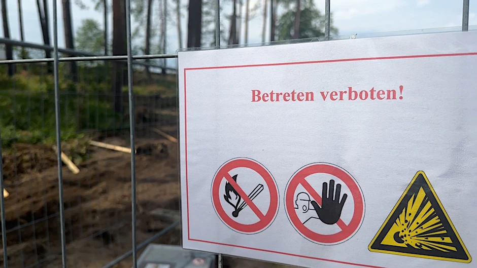 Eine Warntafel weist auf eine Bombenräumung in einem Wald nahe dem Tesla-Werk hin.&nbsp;