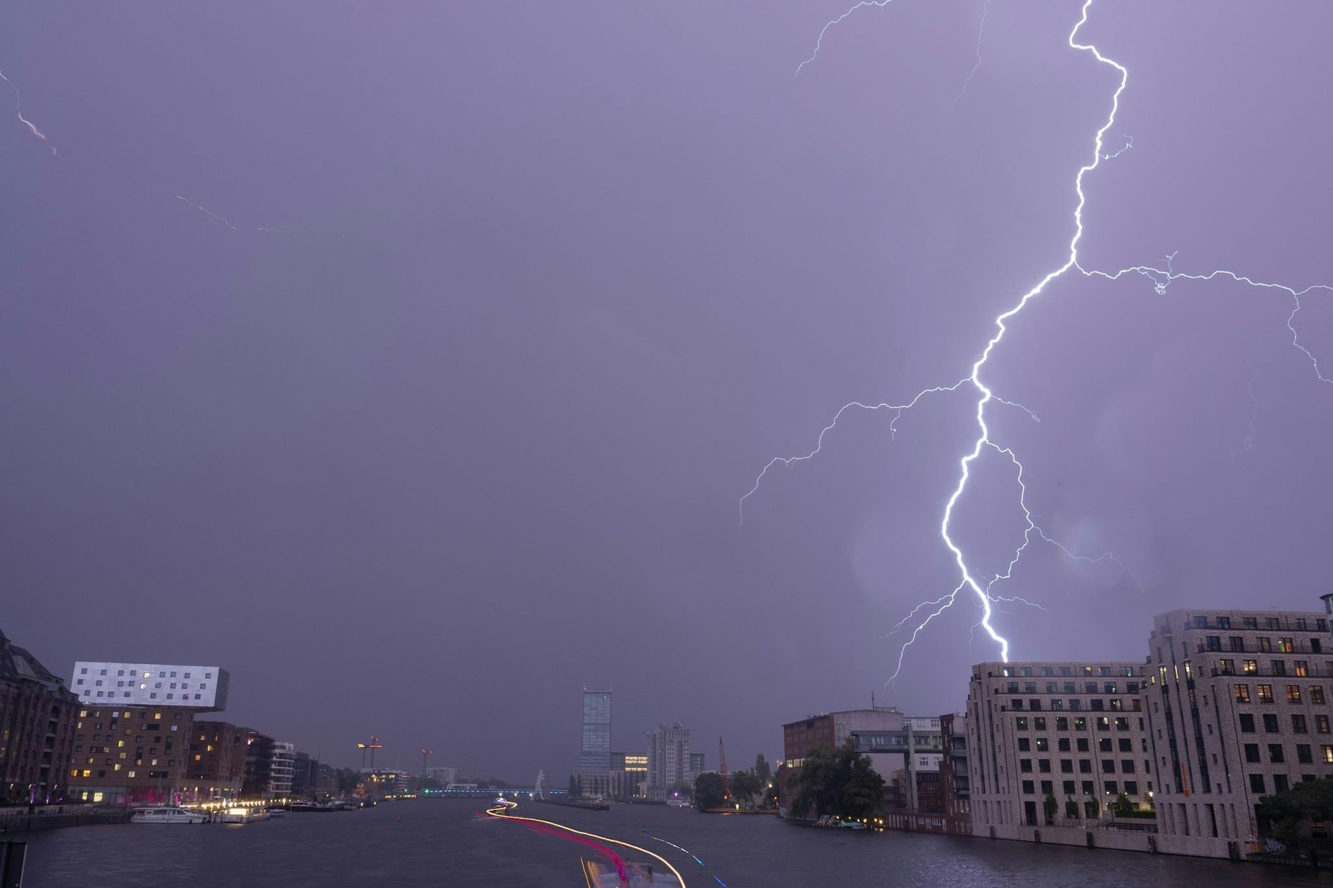 Ein Blitz entlädt sich am späten Abend über der Spree in Richtung Elsenbrücke am Himmel. Am Nachmittag und Abend sind in Berlin Gewitter möglich.