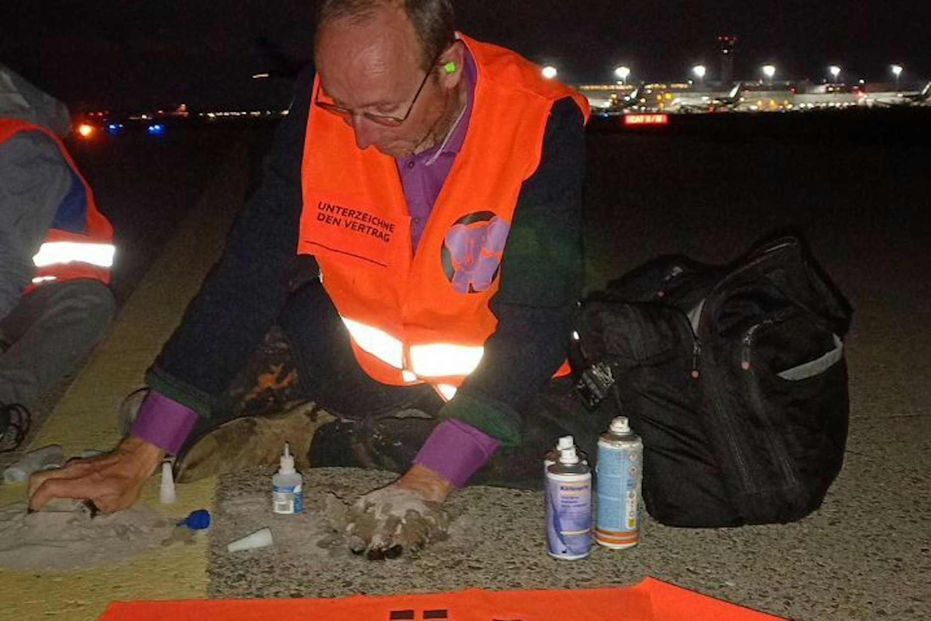 Die Aktivisten kleben sich auf dem Rollfeld des Flughafens Köln/Bonn.
