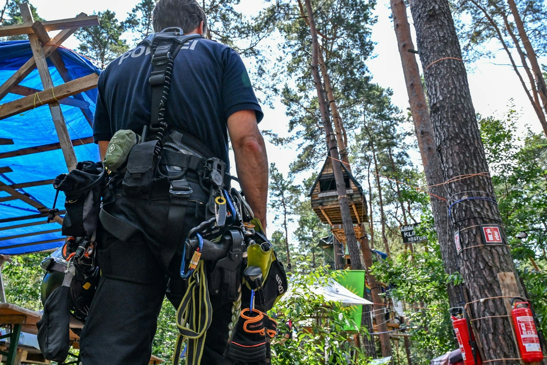 Polizisten durchsuchen am Dienstag das Protestcamp am Tesla-Werk. Am Mittwoch soll eine Weltkriegsbombe gesprengt werden. 