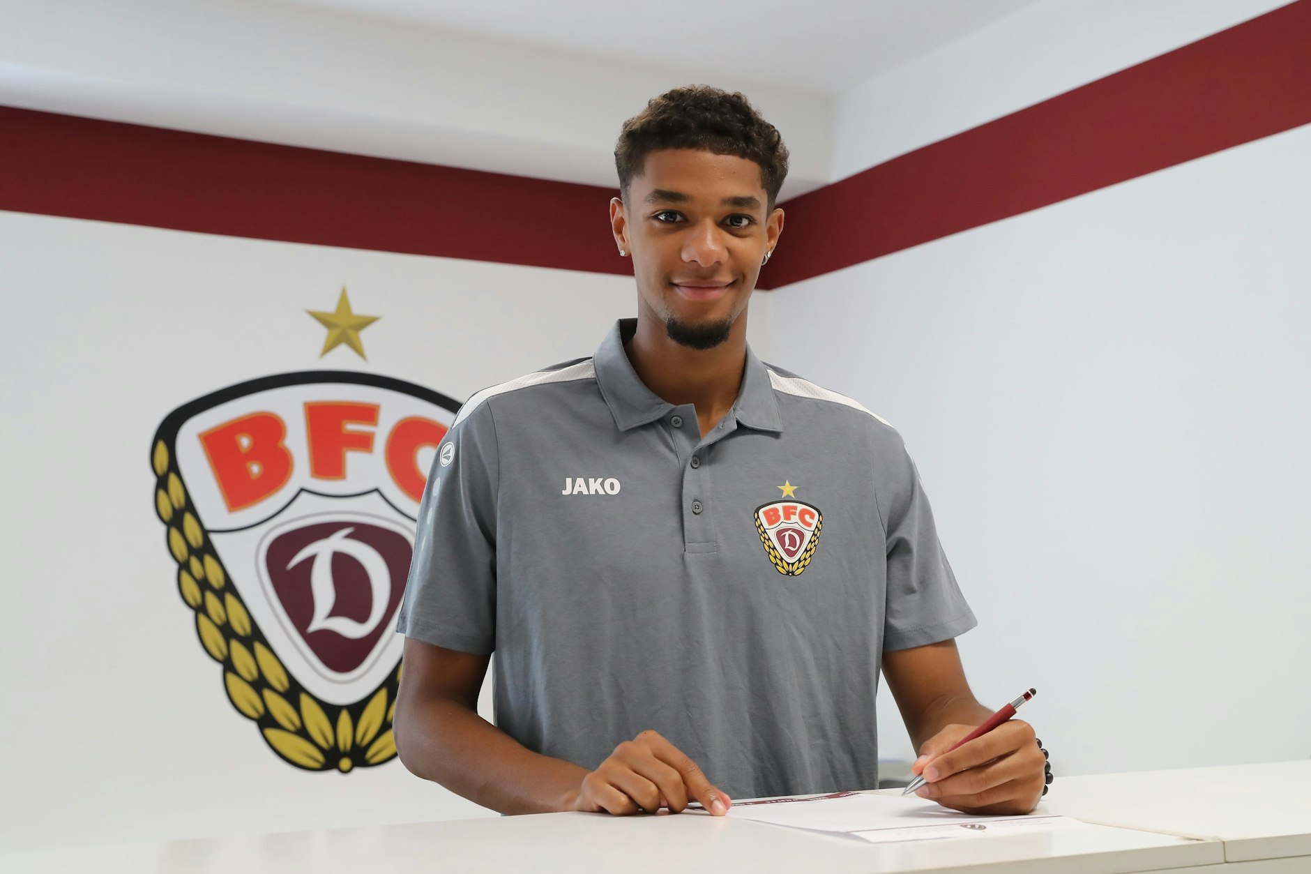 Amiro Amadou unterschreibt mit links seinen Vertrag bei den Dynamos.