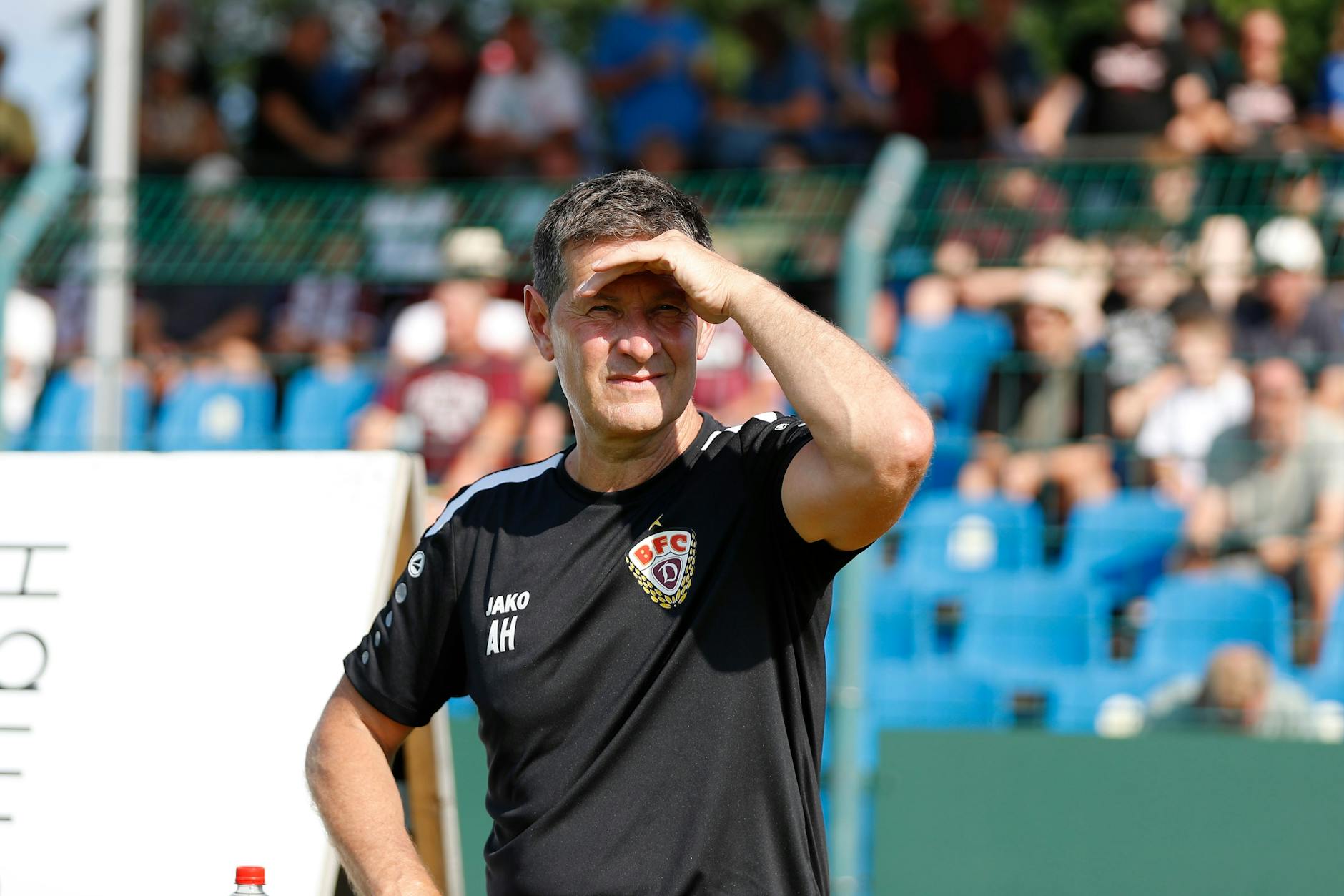 BFC-Trainer Andreas Heraf schirmt die Augen gegen die Sonne ab.