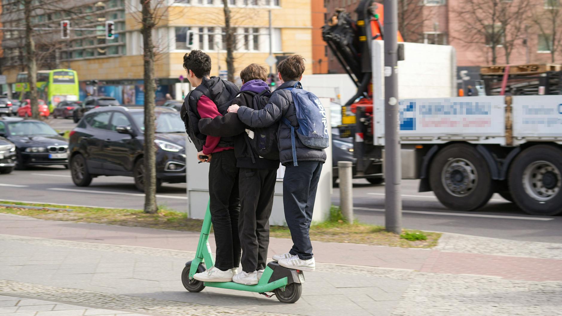 Verboten und gefährlich: drei Personen auf einem E-Scooter. 