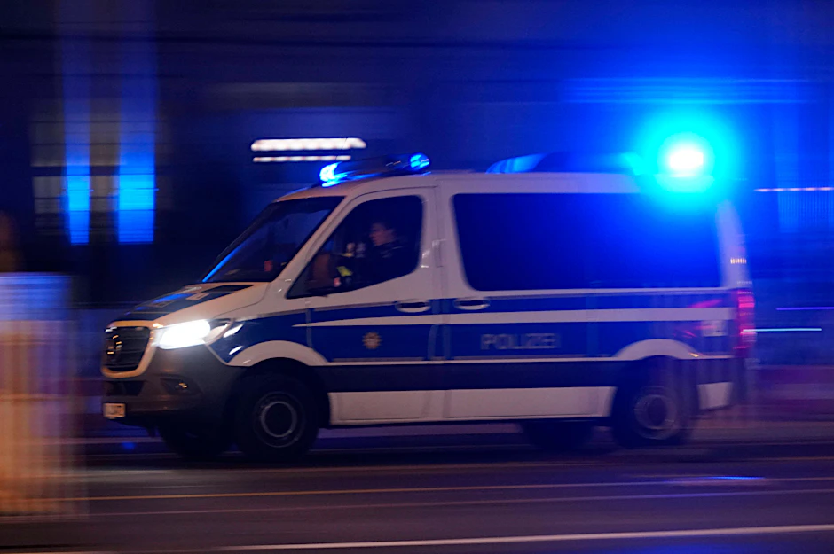 Ein Einsatzwagen der Berliner Polizei fährt nachts zu einem Tatort.