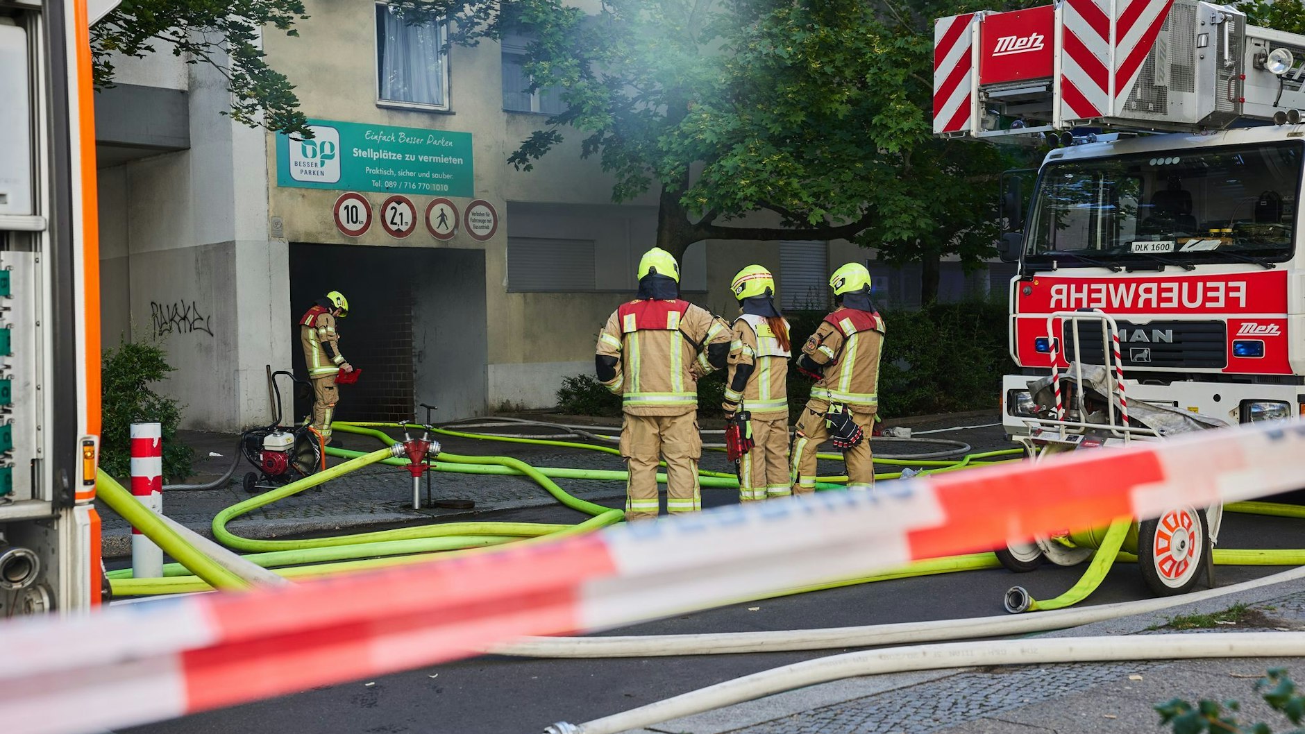 Einsatzkräfte der Feuerwehr löschen ein Feuer in einer Tiefgarage.