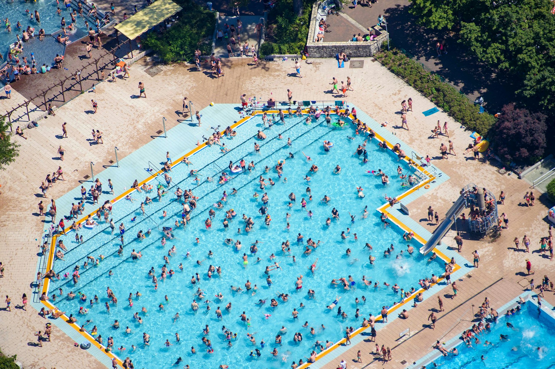 Rein ins Vergnügen, raus aus der Hitze: Kinder und Erwachsene baden und sonnen sich im Sommerbad Wuhlheide.