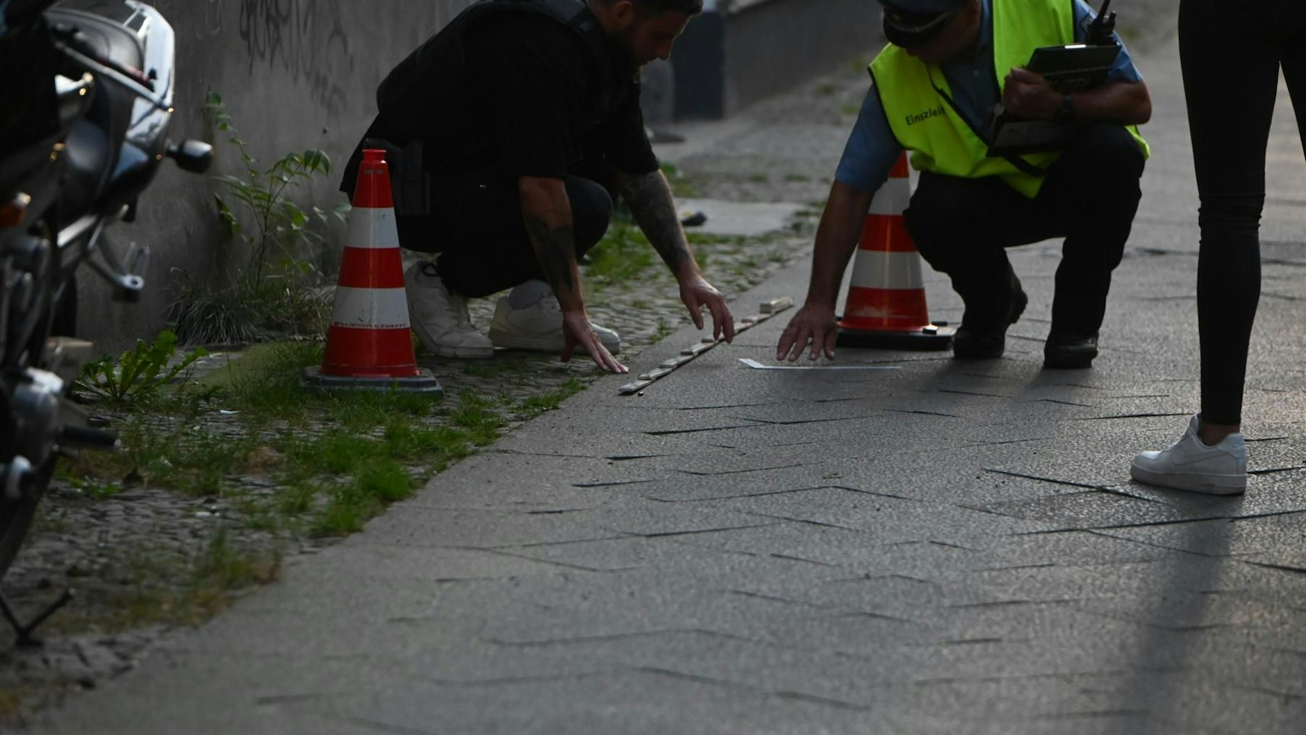 Spurensuche auf dem Gehweg. In der Metzer Straße in Spandau waren am Dienstagabend Schüsse gefallen.