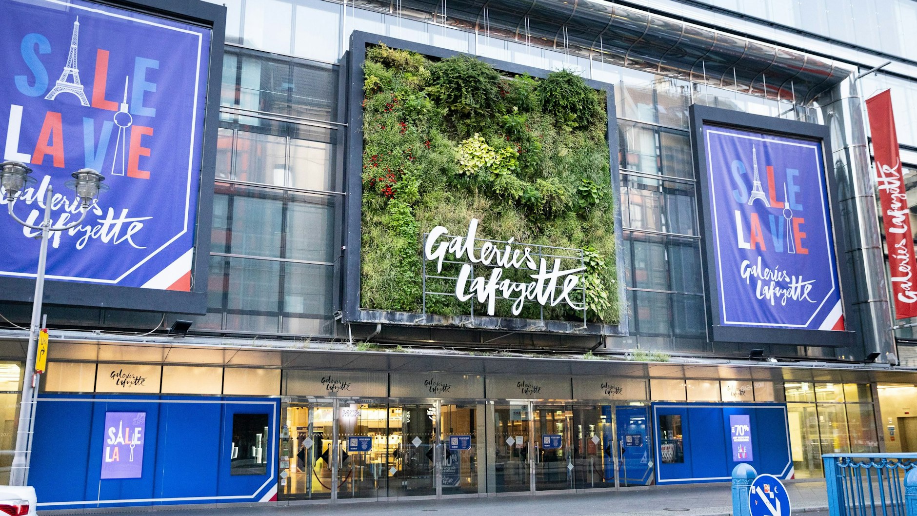 Große Schlussverkaufs-Schilder und Fahnen sind über dem Eingangsbereich des Kaufhauses Galeries Lafayette in Berlin zu sehen