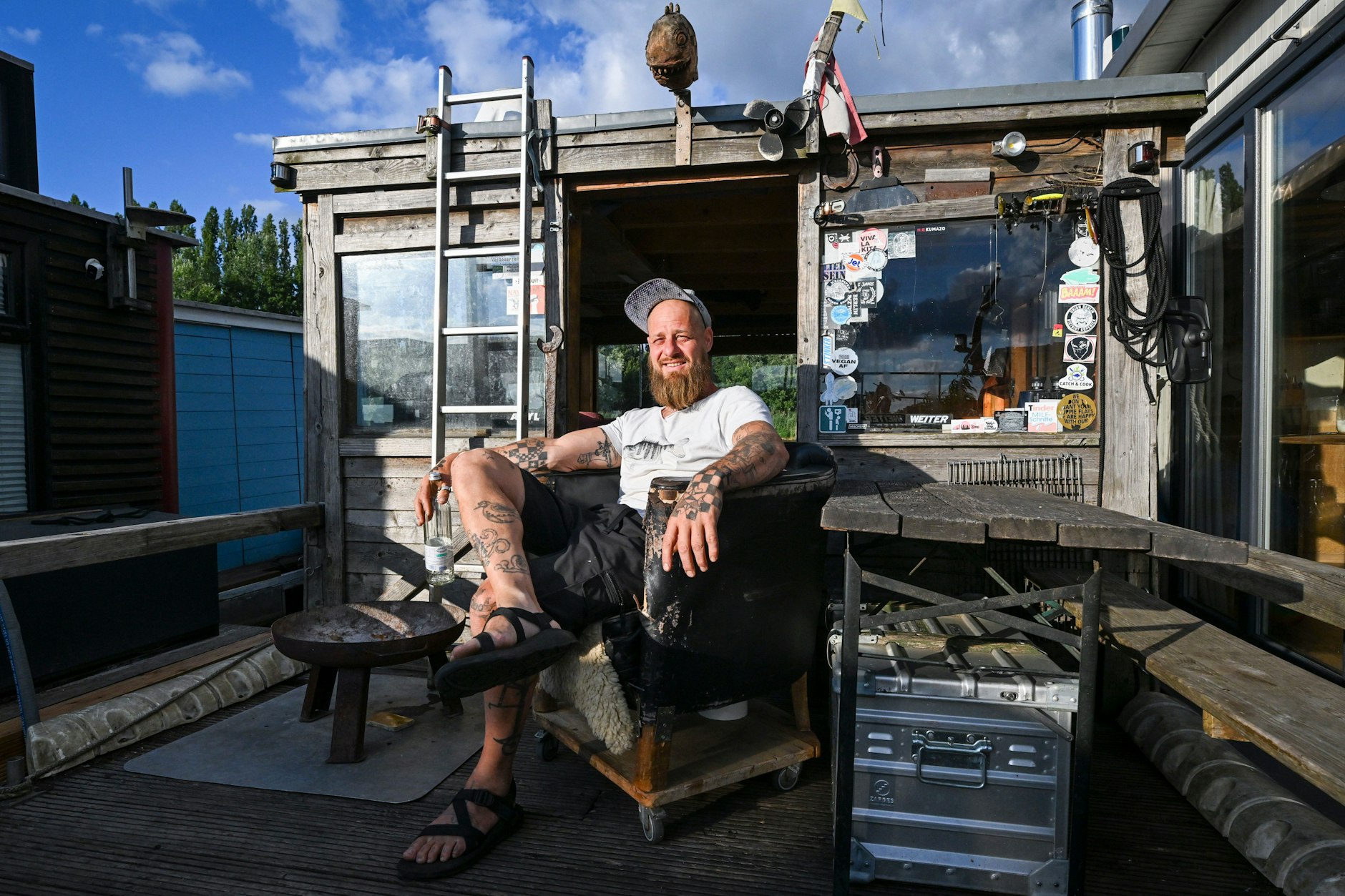 Jan Ebel sitzt in der Rummelsburger Bucht in Berlin auf seinem Hausboot „Rockfisch“, das zu einem Ankerverbund von vier Parteien mit insgesamt fünf Booten gehört.