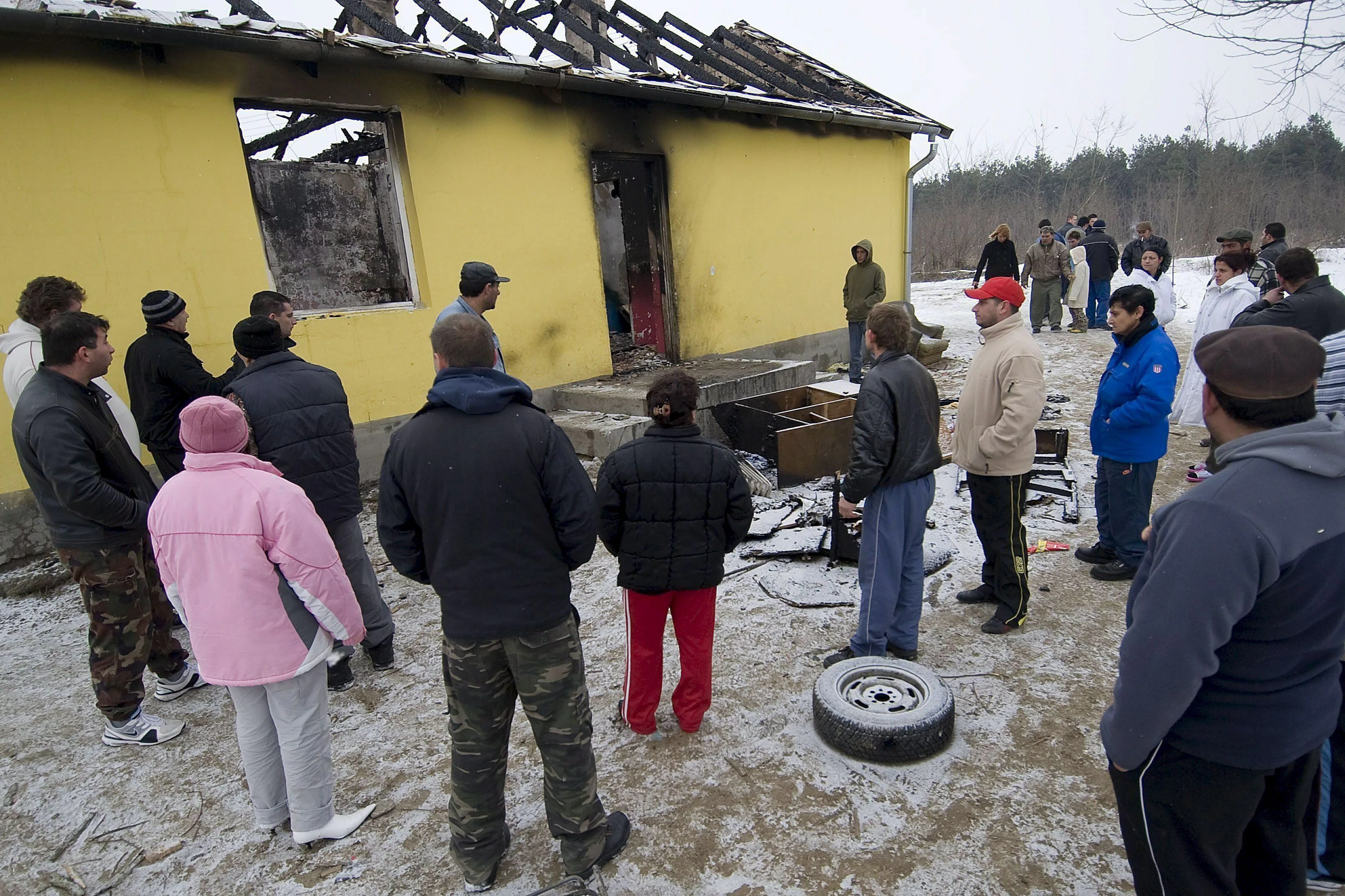 24. Februar 2009: Das Bild zeigt Roma, die vor den Ruinen eines ausgebrannten Familienhauses im ungarischen Tatarszentgyoergy, 55 km südöstlich von Budapest, stehen.