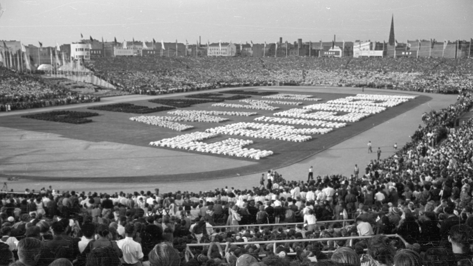 Die Losung „Frieden“ wird in deutscher, russischer und englischer Sprache von den Sportlern zum Abschluss der Veranstaltung dargestellt.
