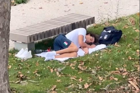 Der italienische Olympia-Sieger Thomas Ceccon schläft vor einer Parkbank im Olympischen Dorf in Paris.