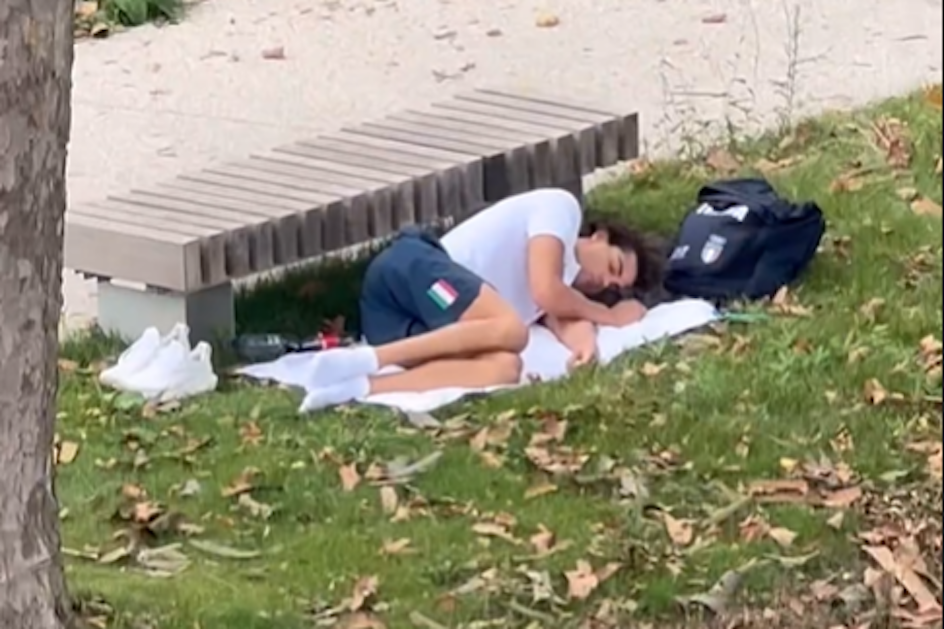 Der italienische Olympia-Sieger Thomas Ceccon schläft vor einer Parkbank im Olympischen Dorf in Paris.