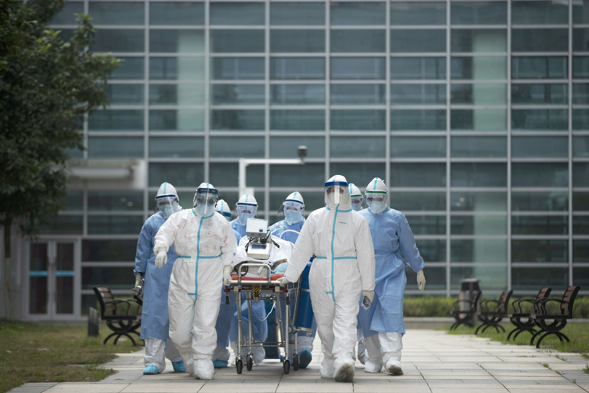 06.03.2020, China, Wuhan: Medizinisches Personal in Schutzkleidung transportiert einen COVID-19-Patienten in den CT-Raum eines Krankenhauses.