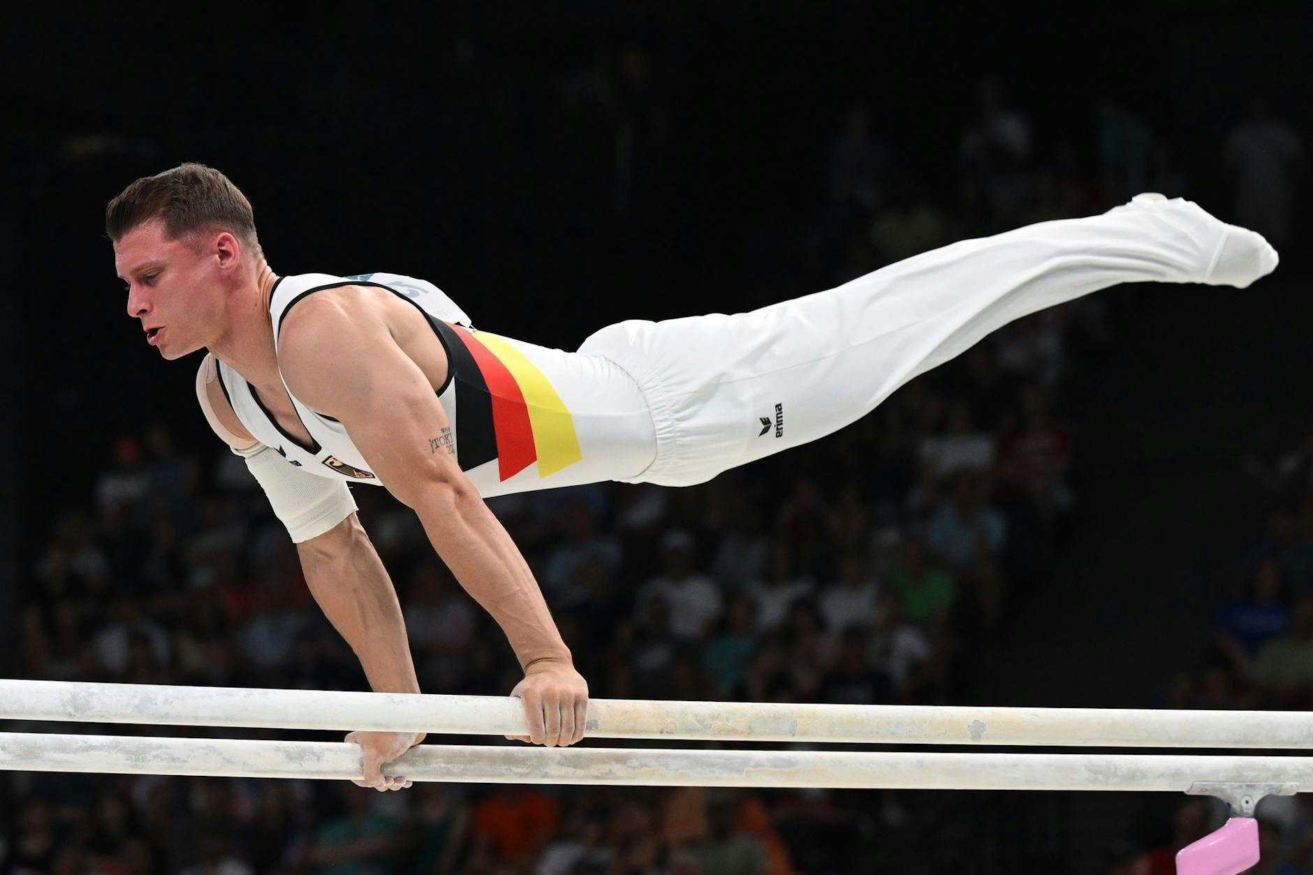Lukas Dauser aus Deutschland zeigt eine Weltklasse-Übung am Barren im Finale der Olympischen Spiele Paris 2024.
