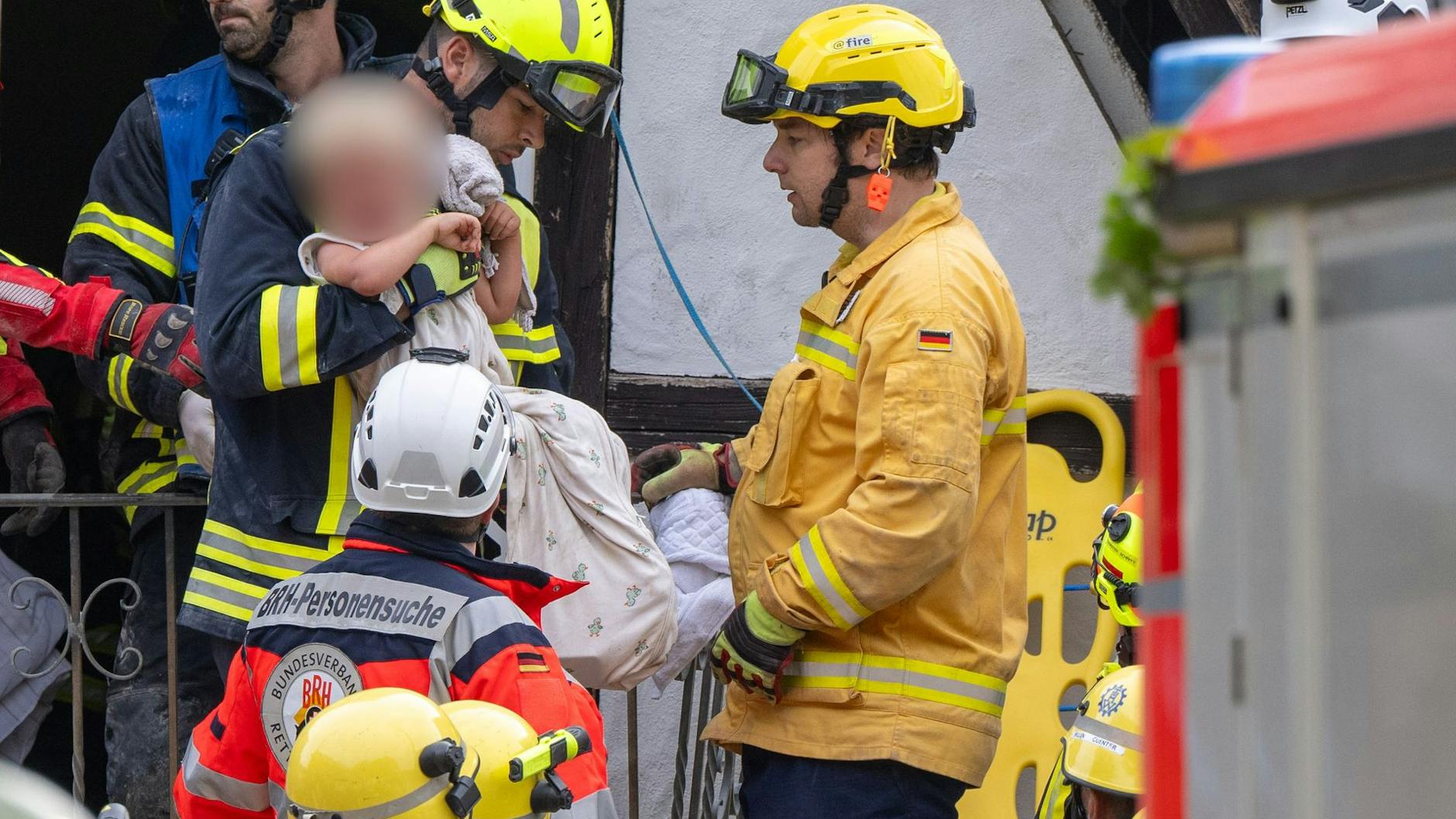 Ein Kleinkind (2) wird von Rettungskräften aus dem eingestürzten Hotel in Kröv gerettet.