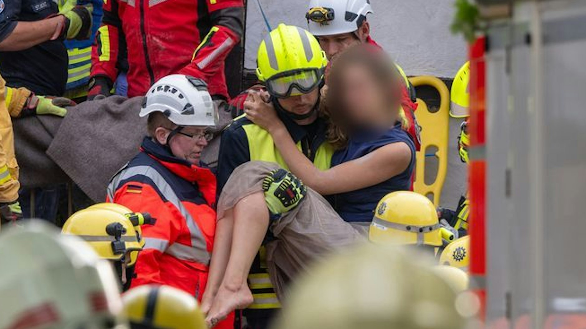 Ein Helfer der Feuerwehr trägt eine verletzte Frau aus der Ruine des Hotels.