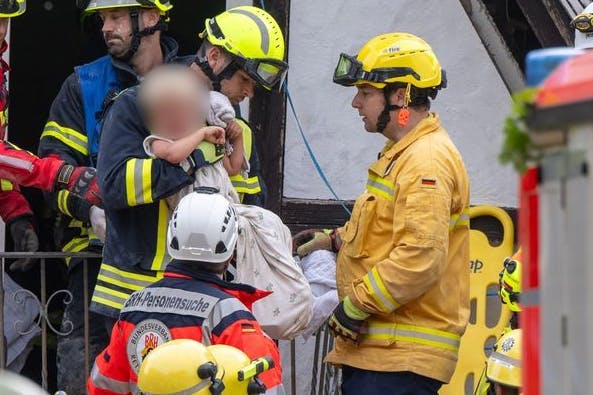 Retter tragen den kleinen Jamie (2) aus den Ruinen des eingestürzten Hotels in Kröv.