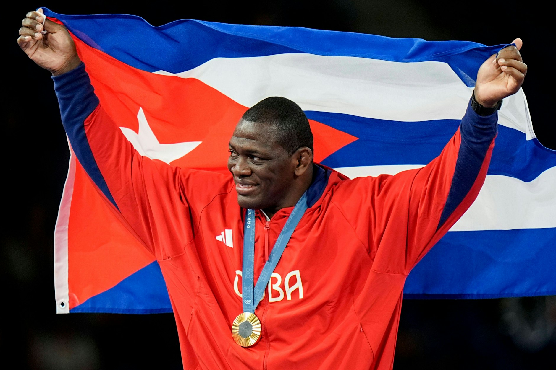 Mijain Lopez feiert seinen fünften Olympiasieg mit Kubas Fahne und der Medaille um den Hals.