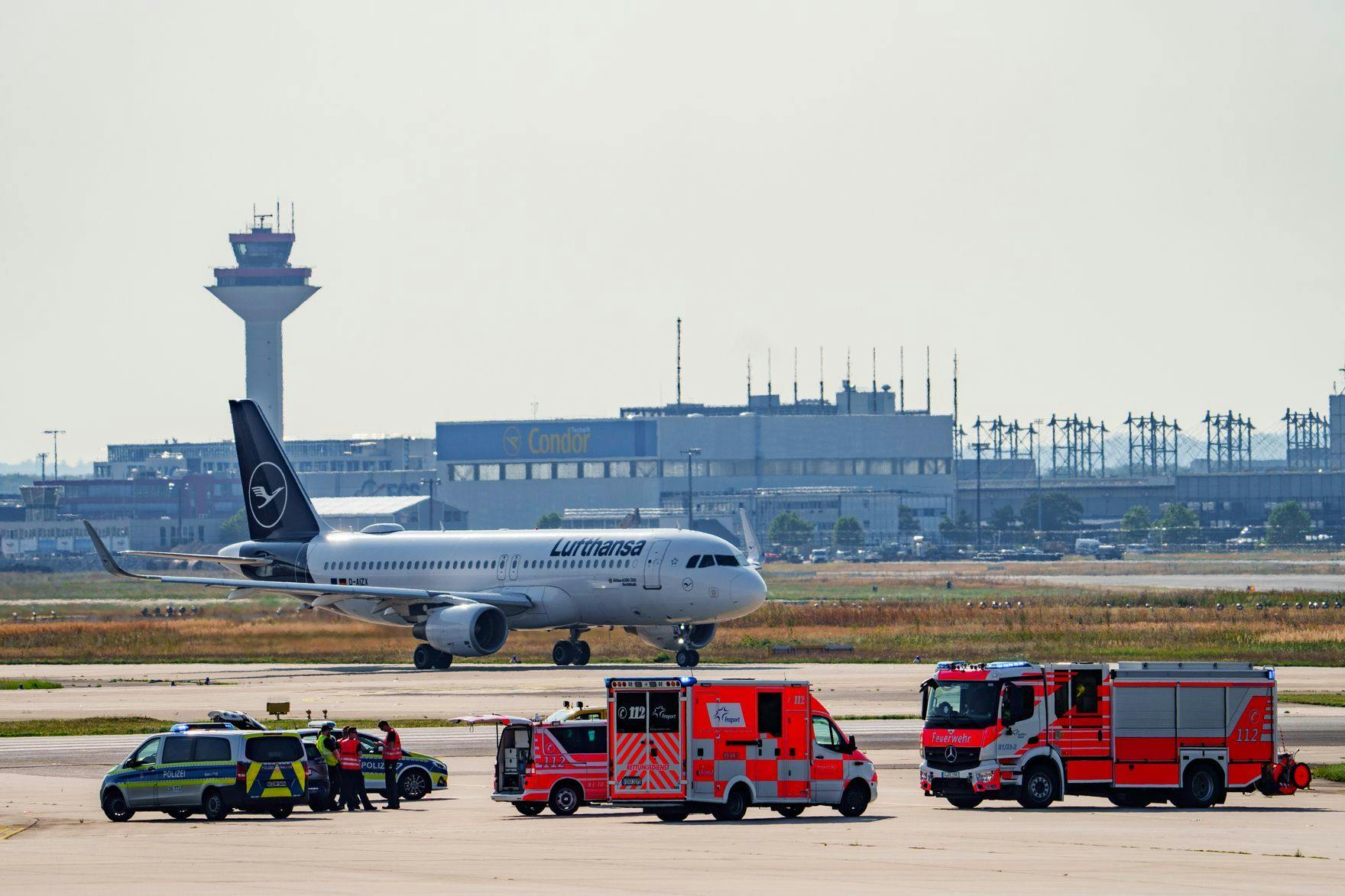 Einsatzkräfte der Polizei und der Flughafenfeuerwehr während der Aktion der Klima-Kleber in Frankfurt. 
